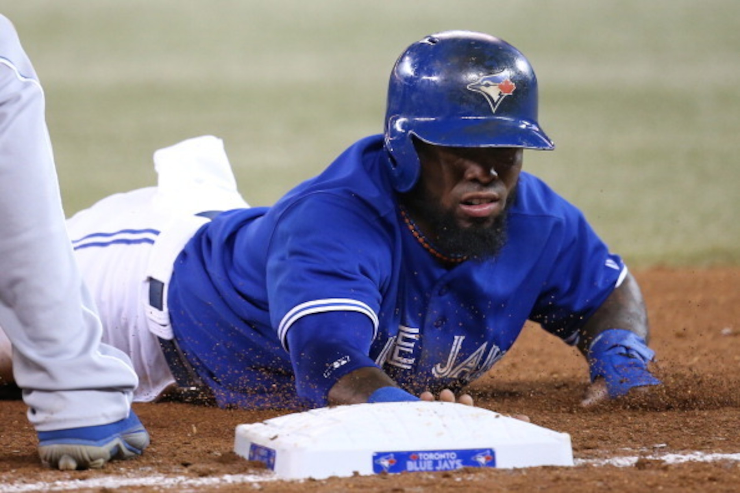 TORONTO, CANADA - AUGUST 31: Jose Reyes #7 of the Toronto Blue Jays dives back to first base in the sixth inning on a pick-off attempt during MLB game action against the Kansas City Royals on August 31, 2013 at Rogers Centre in Toronto, Ontario, Canada. (