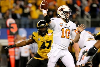 ARLINGTON, TX - JANUARY 03:  Quarterback Clint Chelf #10 of the Oklahoma State Cowboys throws the ball as Kony Ealy #47 of the Missouri Tigers rushes in during the second half during the AT&T Cotton Bowl on January 3, 2014 in Arlington, Texas.  (Photo by 