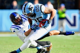 CHAPEL HILL, NC - NOVEMBER 30:  Byron Fields #14 of the Duke Blue Devils tackles Eric Ebron #85 of the North Carolina Tar Heels during play at Kenan Stadium on November 30, 2013 in Chapel Hill, North Carolina. Duke won 27-25.  (Photo by Grant Halverson/Ge
