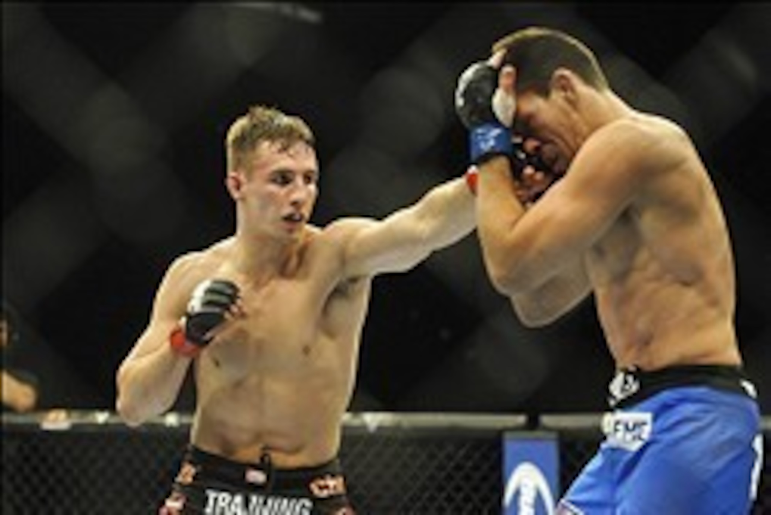 Feb 22, 2014; Las Vegas, NV, USA;  Rory MacDonald (red gloves) lands a punch on Demian Maia (blue gloves) during their UFC welterweight bout at Mandalay Bay. MacDonald won by way of a 29-28 decision. Mandatory Credit: Stephen R. Sylvanie-USA TODAY Sports