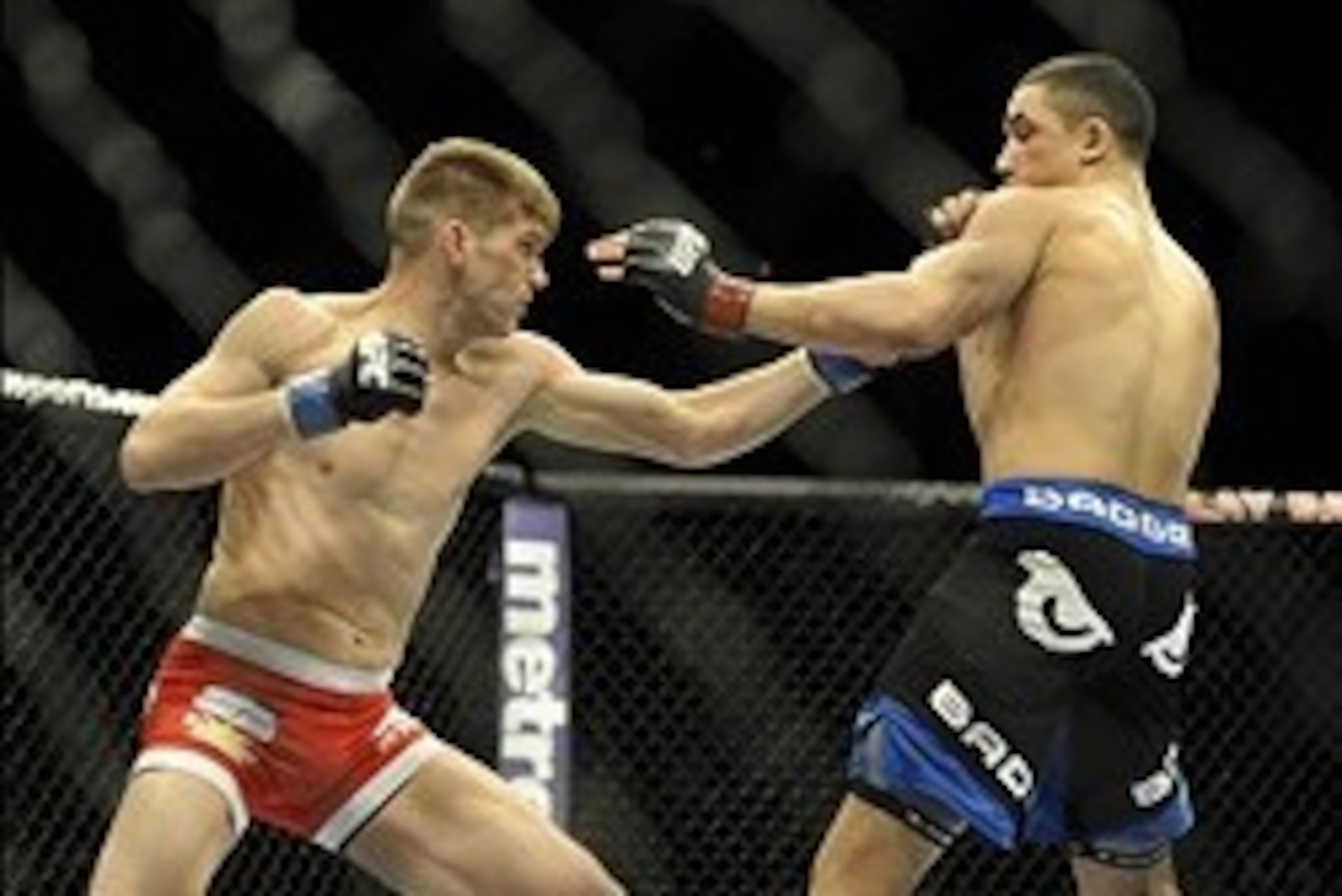 Feb 22, 2014; Las Vegas, NV, USA; Stephen Thompson (blue gloves) swings at Robert Whittaker (red gloves) with a left hook during their UFC welterweight bout at Mandalay Bay. Thompson won with a TKO in the first round. Mandatory Credit: Stephen R. Sylvanie