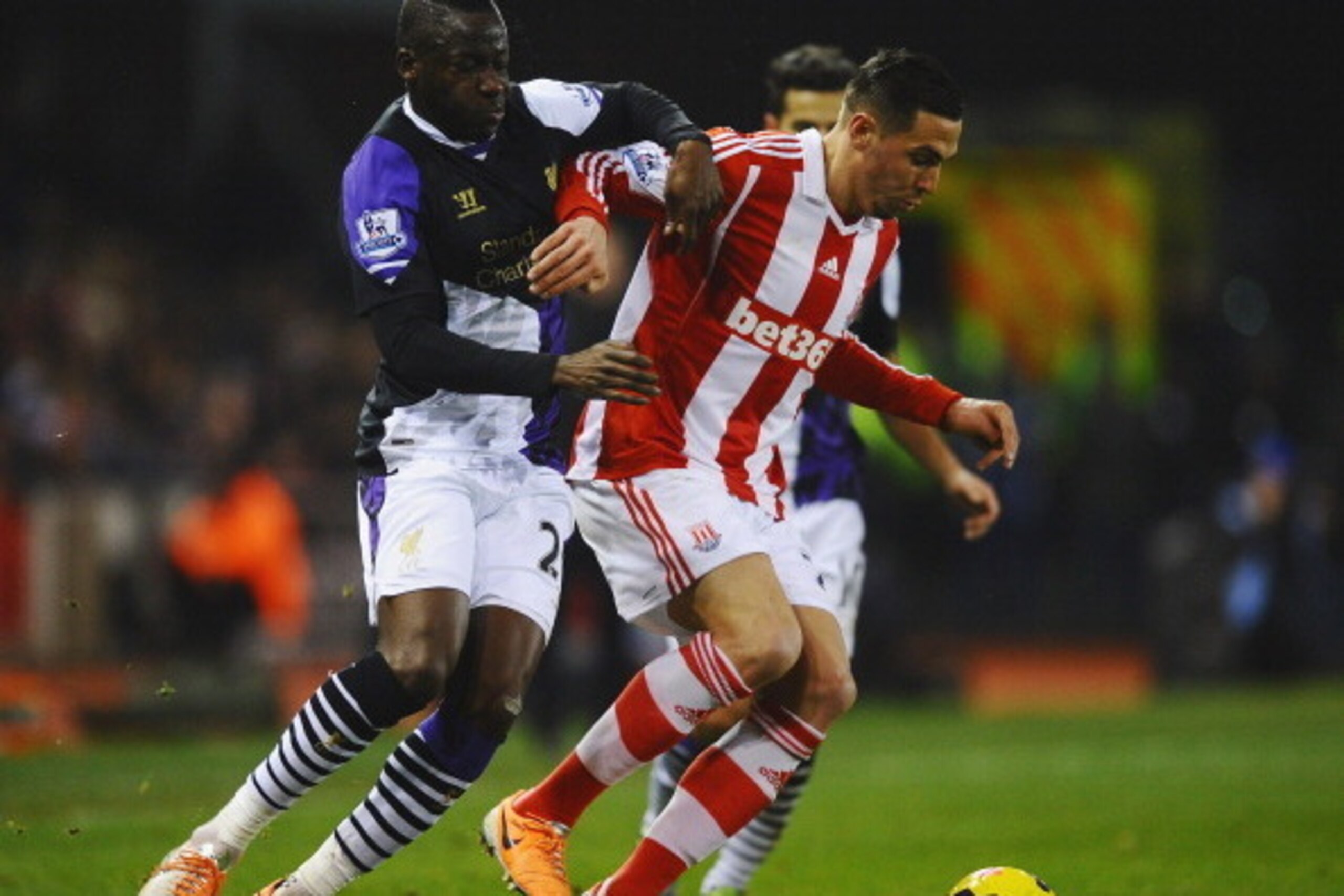 STOKE ON TRENT, ENGLAND - JANUARY 12:  Geoff Cameron of Stoke City holds off Aly Cissokho of Liverpool during the Barclays Premier League match between Stoke City and Liverpool at Britannia Stadium on January 12, 2014 in Stoke on Trent, England.  (Photo b