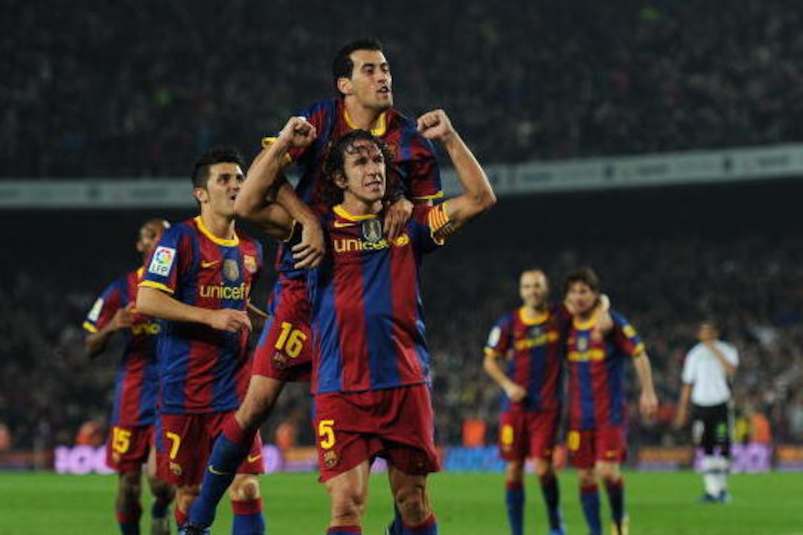 BARCELONA, SPAIN - OCTOBER 16:  Carles Puyol (C) of Barcelona celebrates scoring his team's second goal with his teammate Sergio Busquets (Top) during the La Liga match between Barcelona and Valencia at the Camp Nou stadium on October 16, 2010 in Barcelon