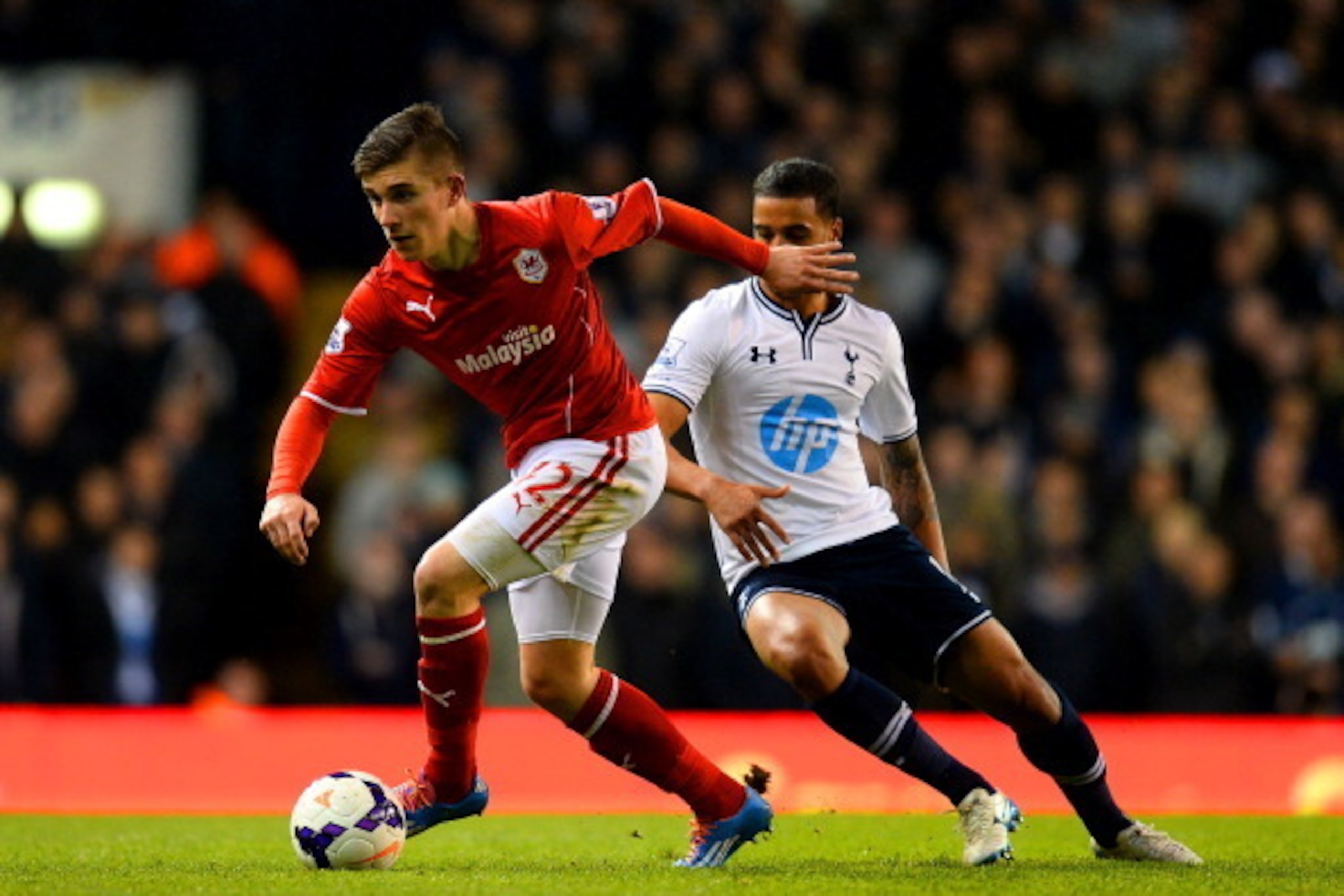 LONDON, ENGLAND - MARCH 02: Declan John of Cardiff City breaks away from Kyle Naughton of Tottenham Hotspur  during the Barclays Premier League match between Tottenham Hotspur and Cardiff City at White Hart Lane on March 2, 2014 in London, England.  (Phot