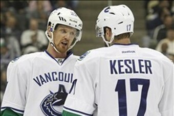 Oct 19, 2013; Pittsburgh, PA, USA; Vancouver Canucks center Henrik Sedin (33) and center Ryan Kesler (17) talk on the ice against the Pittsburgh Penguins during the first period at the CONSOL Energy Center. The Pens won 4-3 in a shootout. Mandatory Credit