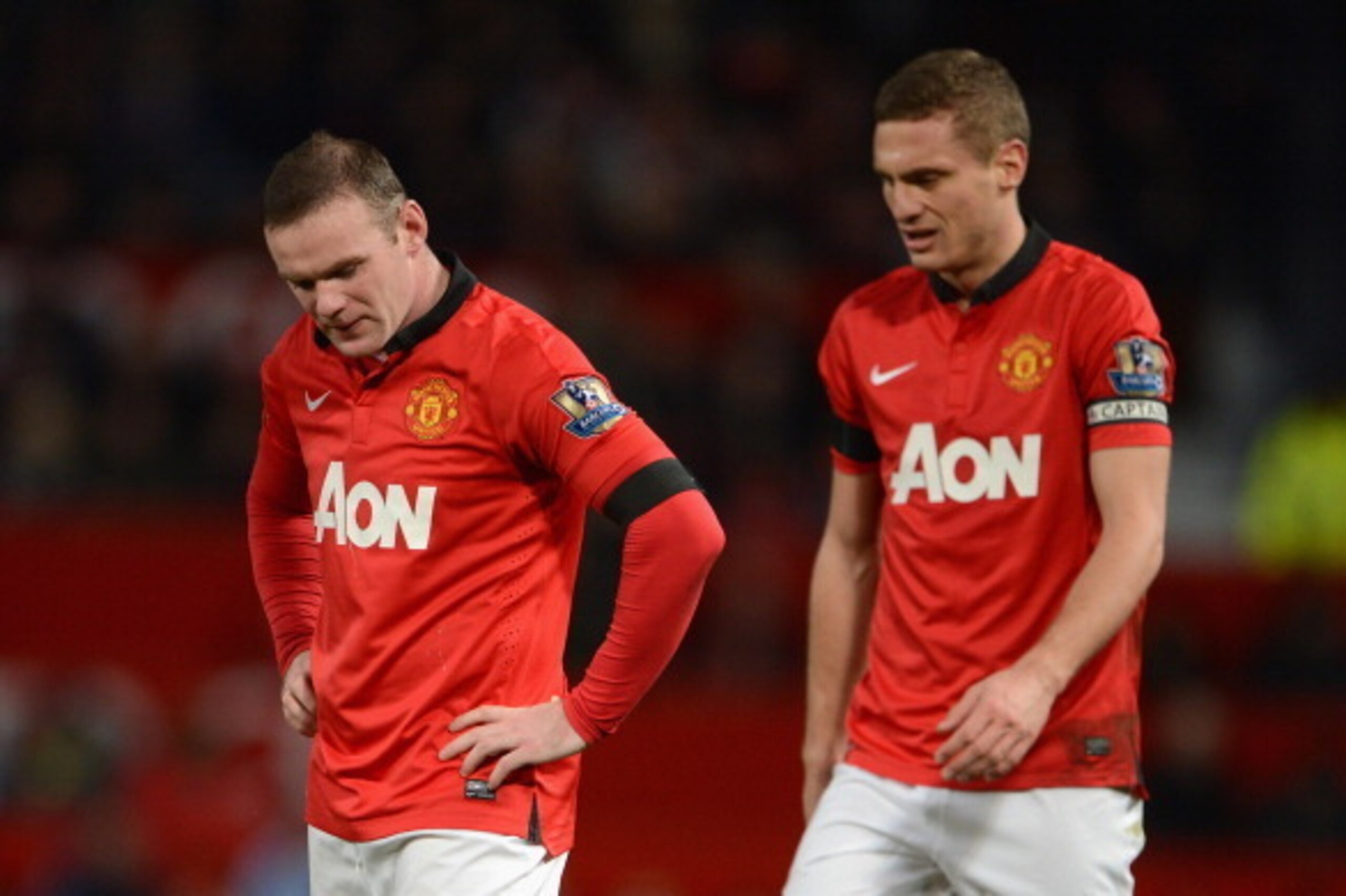 MANCHESTER, ENGLAND - FEBRUARY 09:  Wayne Rooney of Manchester United looks on with Nemanja Vidic (R) during the Barclays Premier League match between Manchester United and Fulham at Old Trafford on February 9, 2014 in Manchester, England.  (Photo by Mich