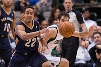 Feb 26, 2014; Dallas, TX, USA; Dallas Mavericks point guard Jose Calderon (8) steals the ball from New Orleans Pelicans point guard Brian Roberts (22) during the second half at the American Airlines Center. The Mavericks defeated the Pelicans 108-89. Mand