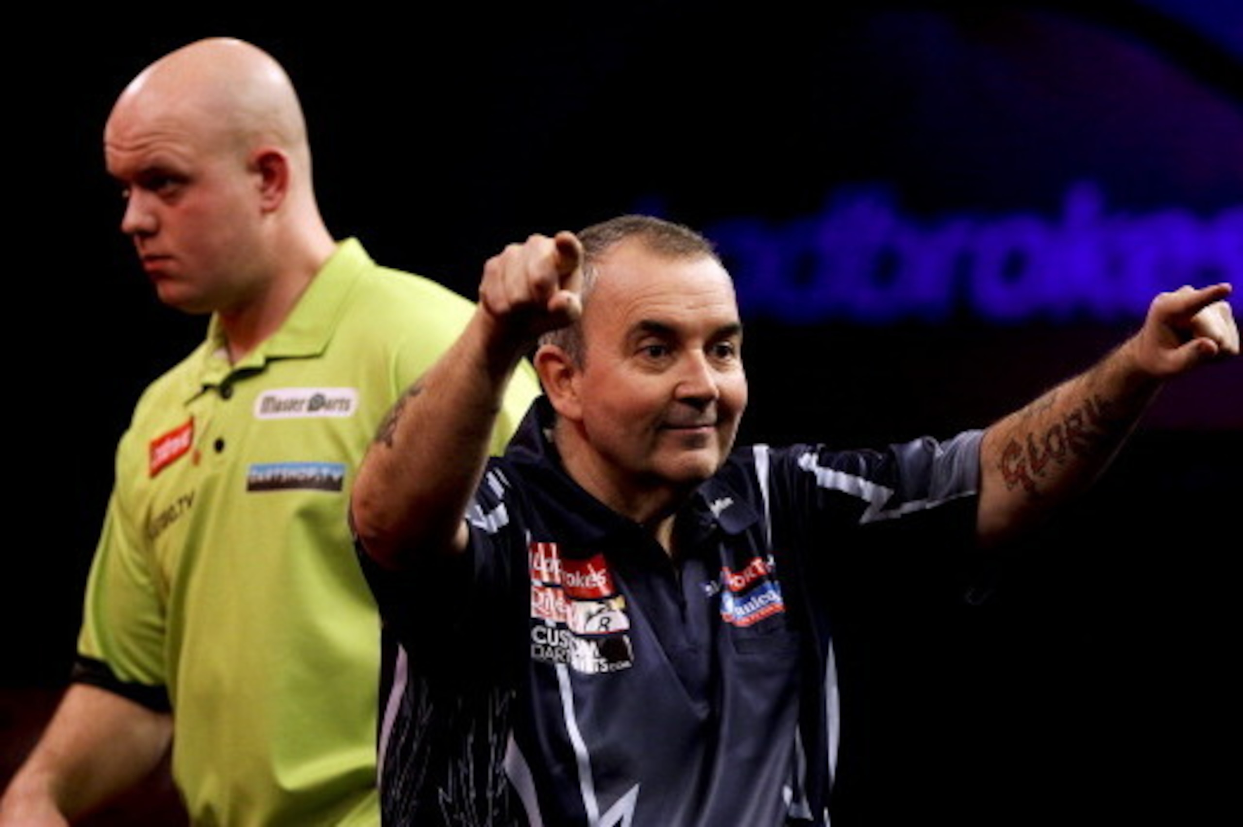 LONDON, ENGLAND - JANUARY 1: Phil Taylor celebrates winning the tenth set as Michael van Gerwen of the Netherlands looks on during the final of the 2013 Ladbrokes.com World Darts Championship at the Alexandra Palace on January 1, 2013 in London, England. 
