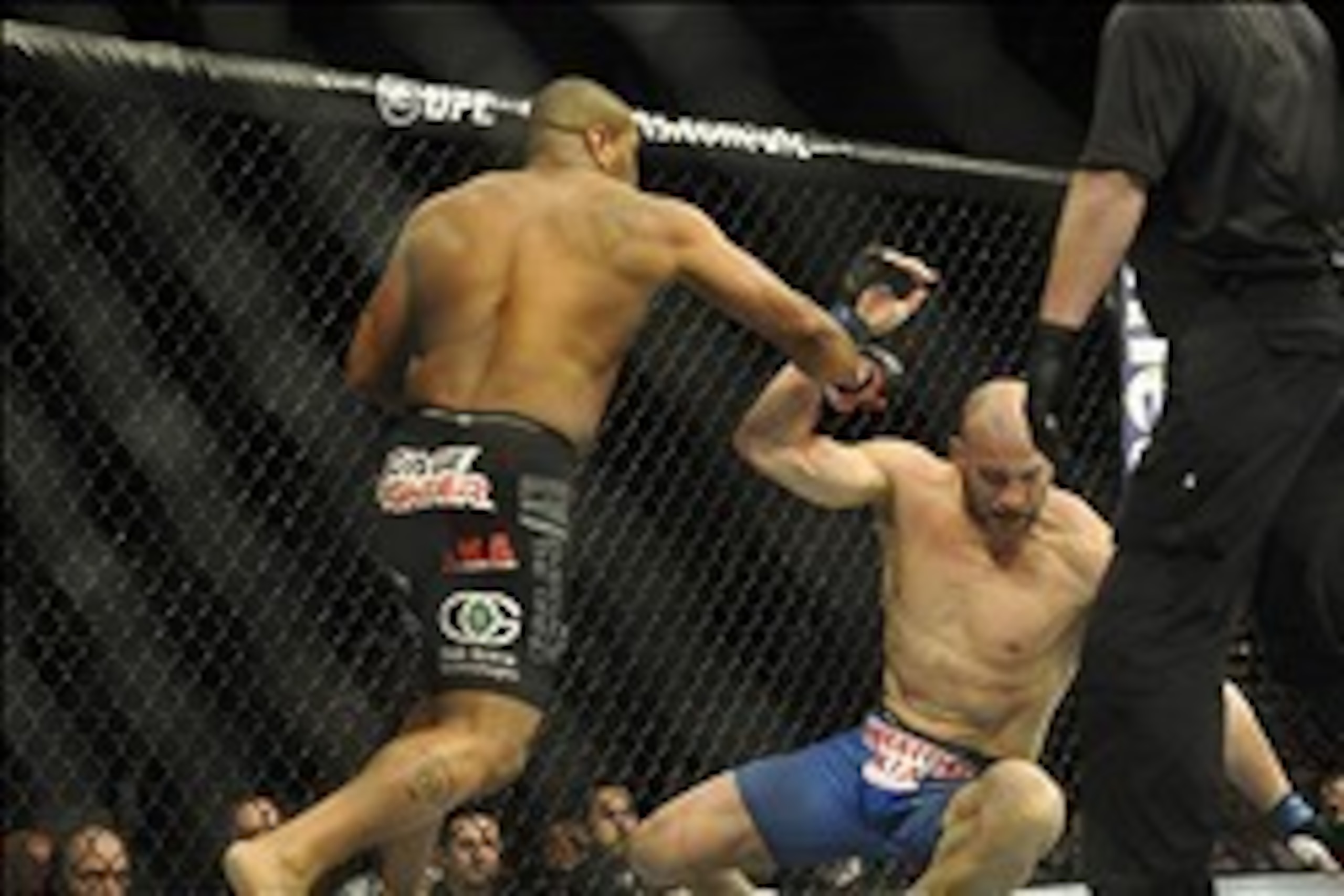 Feb 22, 2014; Las Vegas, NV, USA; Patrick Cummins (blue gloves)  falls to the mat after being hit by Daniel Cormier (red gloves) during their UFC light heavyweight bout at Mandalay Bay. Cormier won by way of a TKO in the first round. Mandatory Credit: Ste