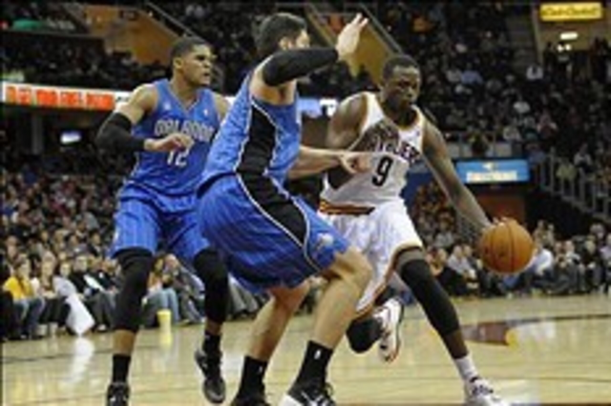 Feb 19, 2014; Cleveland, OH, USA; Cleveland Cavaliers small forward Luol Deng (9) drives against Orlando Magic small forward Tobias Harris (12) and center Nikola Vucevic (9) in the third quarter at Quicken Loans Arena. Mandatory Credit: David Richard-USA 