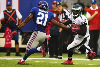 EAST RUTHERFORD, NJ - OCTOBER 06:   Michael Vick #7 of the Philadelphia Eagles scrambles against  Ryan Mundy #21 of the New York Giants during their game at MetLife Stadium on October 6, 2013 in East Rutherford, New Jersey.  (Photo by Al Bello/Getty Image