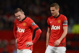 MANCHESTER, ENGLAND - FEBRUARY 09:  Wayne Rooney of Manchester United looks on with Nemanja Vidic (R) during the Barclays Premier League match between Manchester United and Fulham at Old Trafford on February 9, 2014 in Manchester, England.  (Photo by Mich