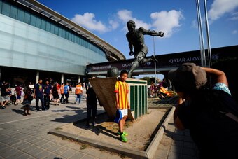 BARCELONA, SPAIN - AUGUST 18:  A young FC Barcelona fan poses for a photograph next to the statue of Ladislao Kubala outside the Camp Nou Stadium prior to the La Liga match between FC Barcelona and Levante UD on August 18, 2013 in Barcelona, Spain.  (Phot