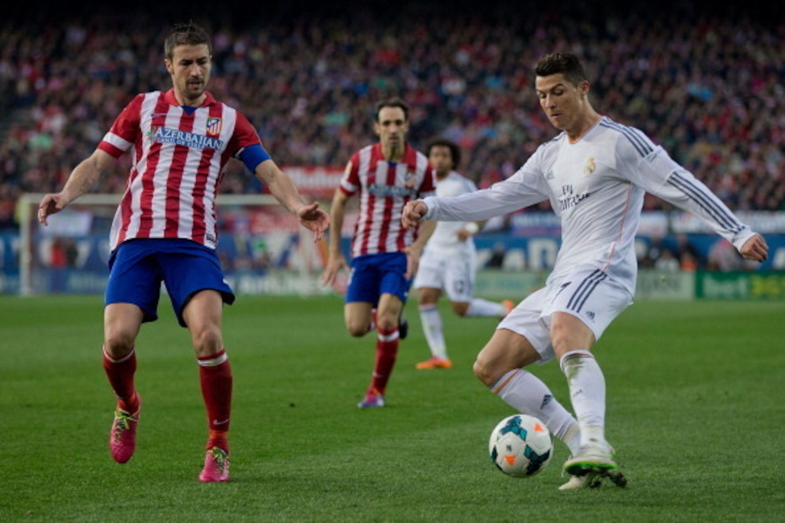MADRID, SPAIN - MARCH 02: Cristiano Ronaldo (R) of Real Madrid CF competes for the ball with Gabi Fernandez (L) of Atletico de Madrid during the La Liga match between Club Atletico de Madrid and Real Madrid CF at Vicente Calderon Stadium on March 2, 2014 