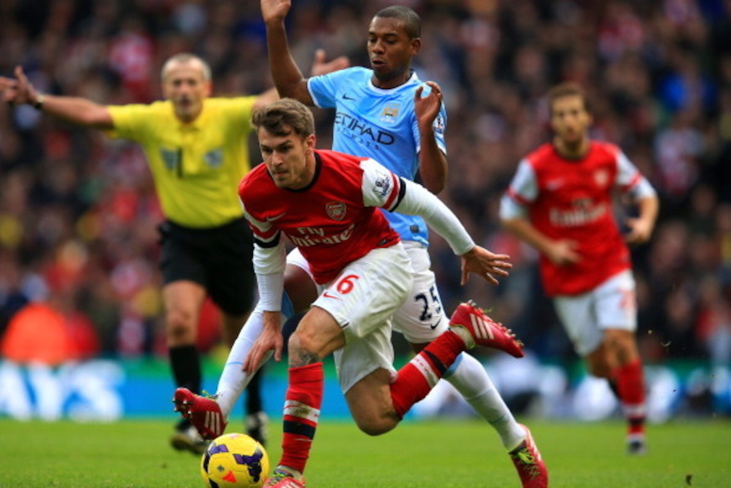 MANCHESTER, ENGLAND - DECEMBER 14: Aaron Ramsey of Arsenal and Fernandinho of Manchester City battle for the ball during the Barclays Premier League match between Manchester City and Arsenal at Etihad Stadium on December 14, 2013 in Manchester, England. (