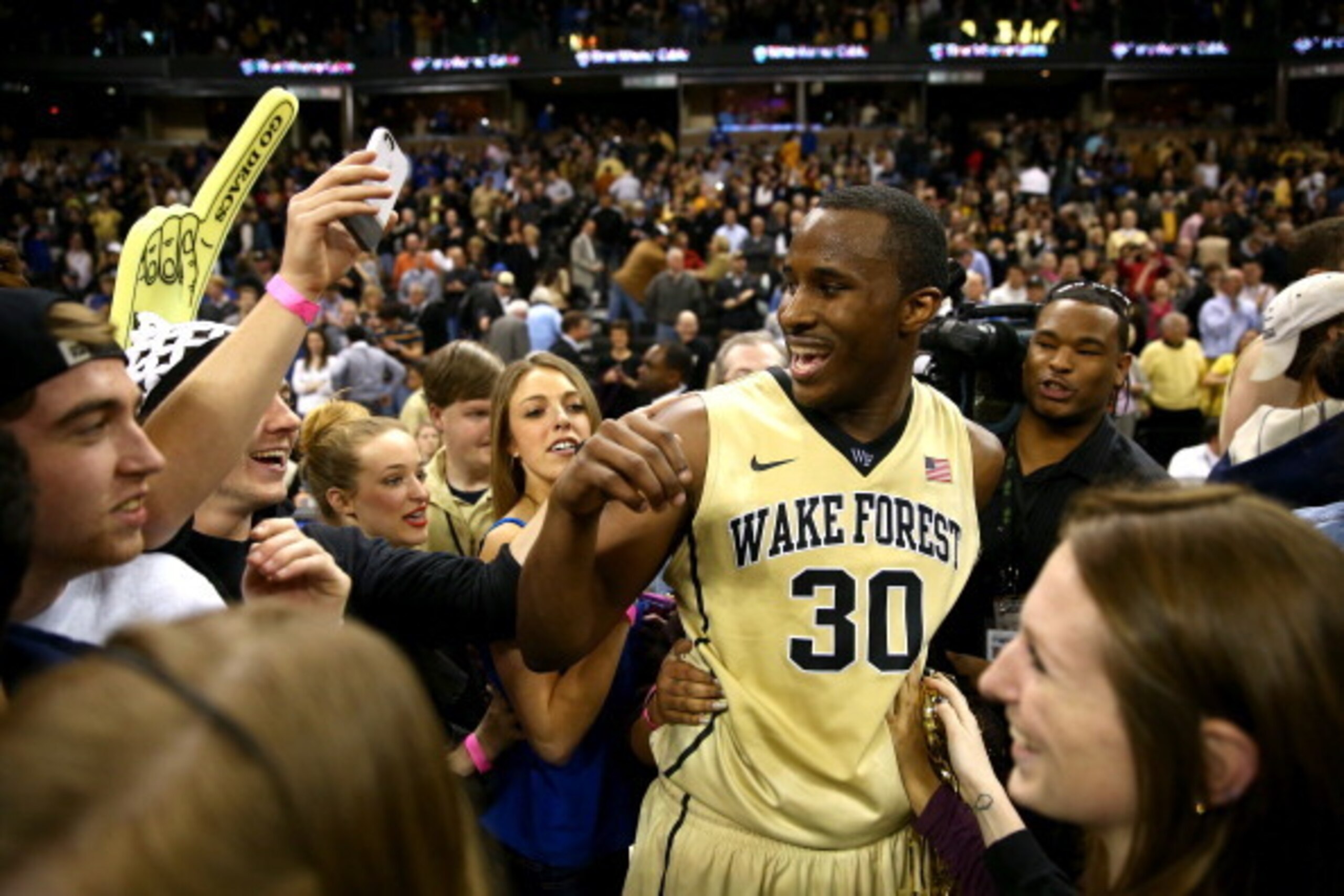 WINSTON-SALEM, NC - MARCH 05:  Travis McKie #30 of the Wake Forest Demon Deacons celebrates with students after defeating the Duke Blue Devils 82-72 at Joel Coliseum on March 5, 2014 in Winston-Salem, North Carolina.  (Photo by Streeter Lecka/Getty Images