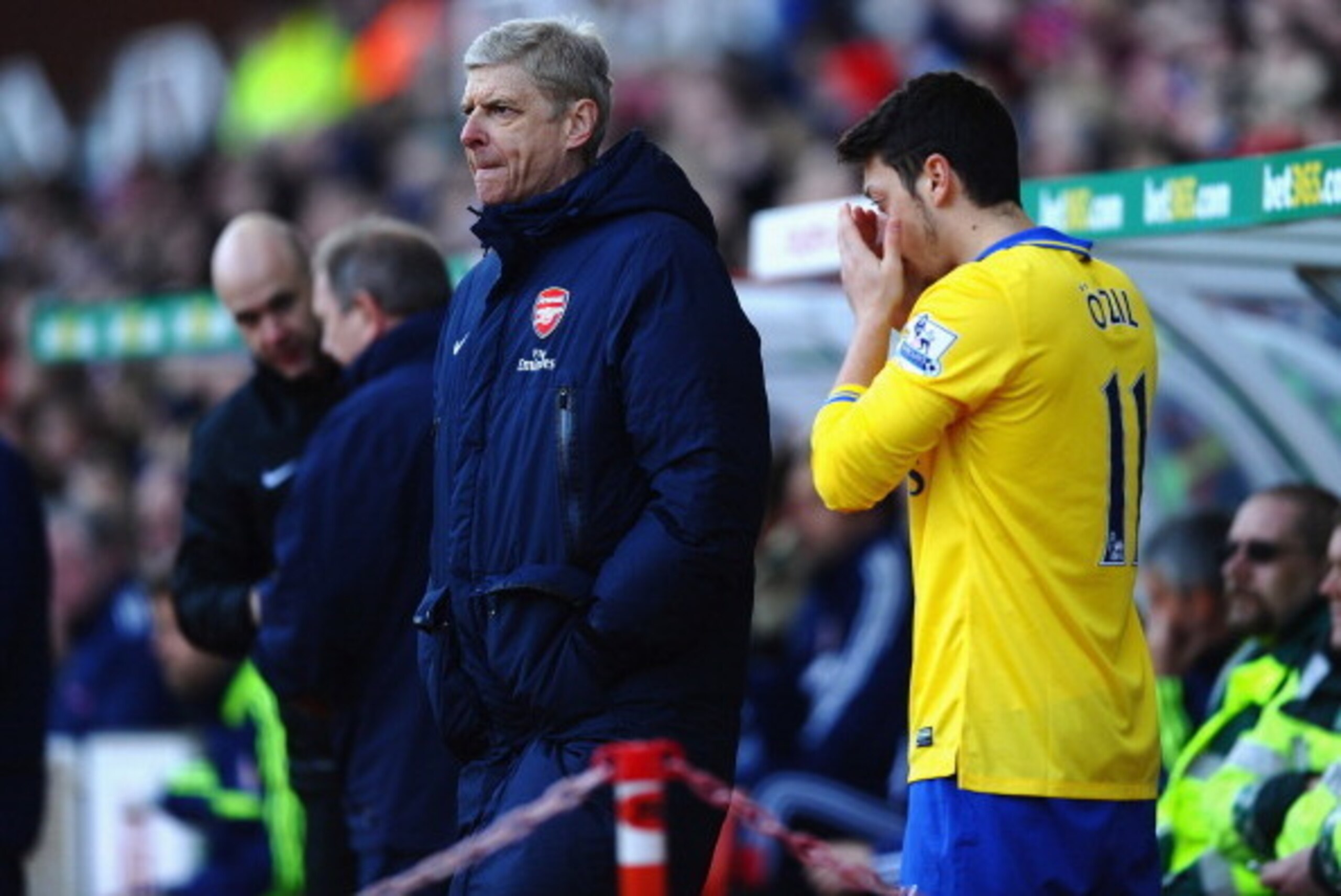 STOKE ON TRENT, ENGLAND - MARCH 01: Arsene Wenger of Arsenal bring on substitute Mesut Ozil during the Barclays Premier League match between Stoke City and Arsenal at Britannia Stadium on March 1, 2014 in Stoke on Trent, England. (Photo by Laurence Grif STOKE ON TRENT, ENGLAND - MARCH 01: Arsene Wenger of Arsenal bring on substitute Mesut Ozil during the Barclays Premier League match between Stoke City and Arsenal at Britannia Stadium on March 1, 2014 in Stoke on Trent, England. (Photo by Laurence Grif