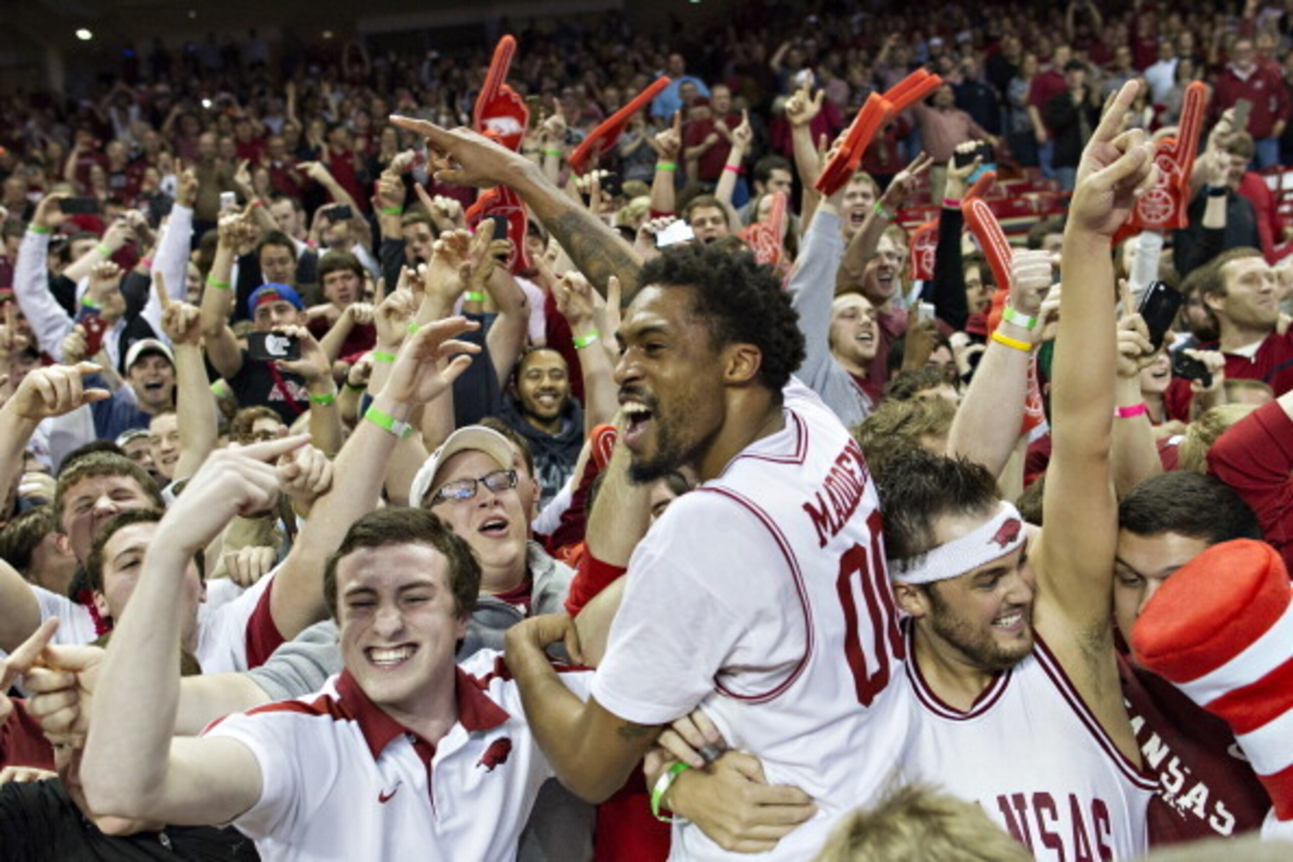 FAYETTEVILLE, AR - FEBRUARY 5:  Rashad Madden #00 of the Arkansas Razorbacks celebrates with the student section after a game against the Florida Gators at Bud Walton Arena on February 5, 2013 in Fayetteville, Arkansas.  The Razorbacks defeated the Gators