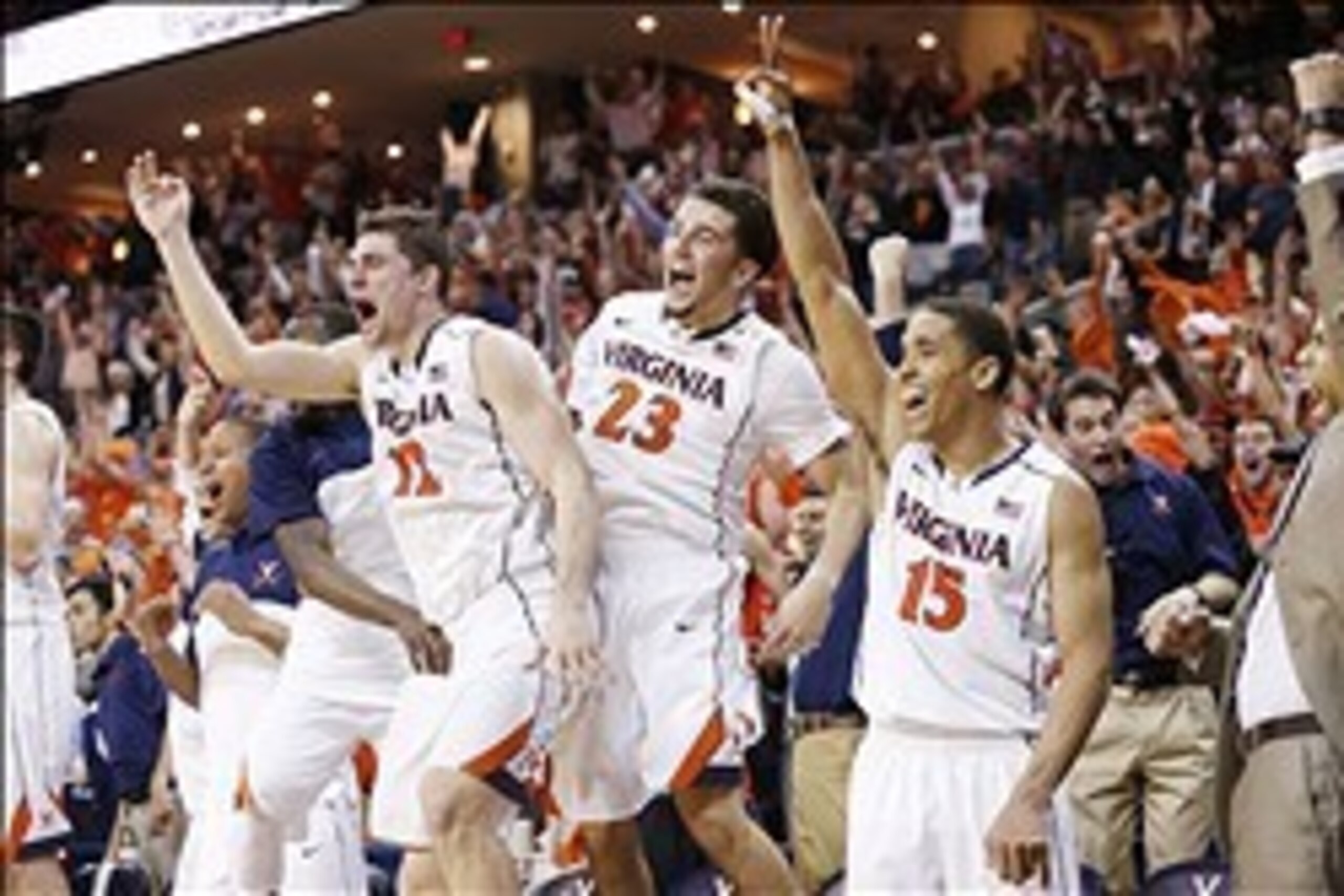 Mar 1, 2014; Charlottesville, VA, USA; Virginia Cavaliers guard Joe Harris (12), Cavaliers guard London Perrantes (23), and Cavaliers guard Malcolm Brogdon (15) celebrate on the bench in the final seconds against the Syracuse Orange at John Paul Jones Are