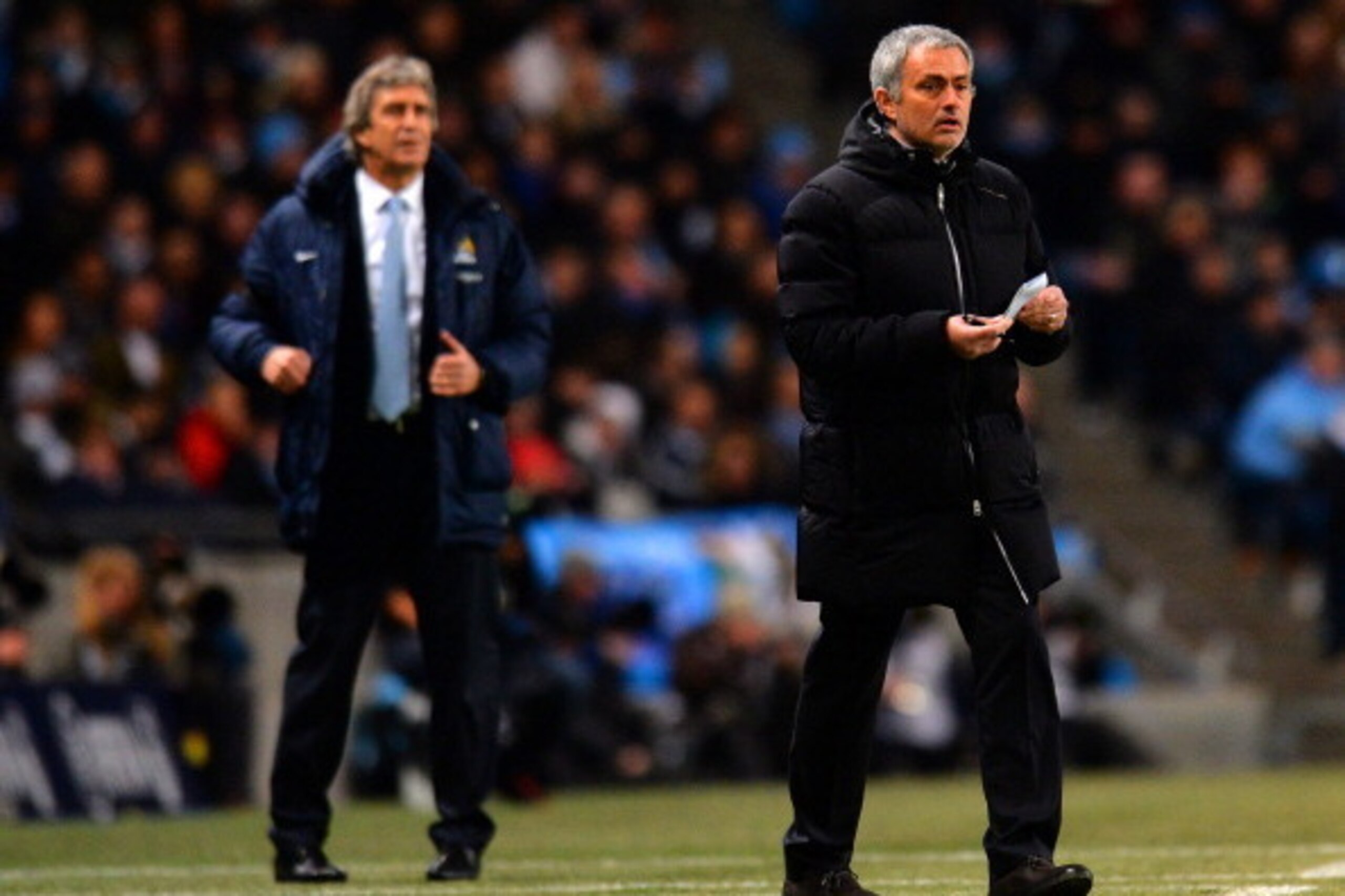MANCHESTER, ENGLAND - FEBRUARY 03: Manuel Pellegrini manager of Manchester City and Jose Mourinho manager of Chelsea give instructions during the Barclays Premier League match between Manchester City and Chelsea at Etihad Stadium on February 3, 2014 in Ma