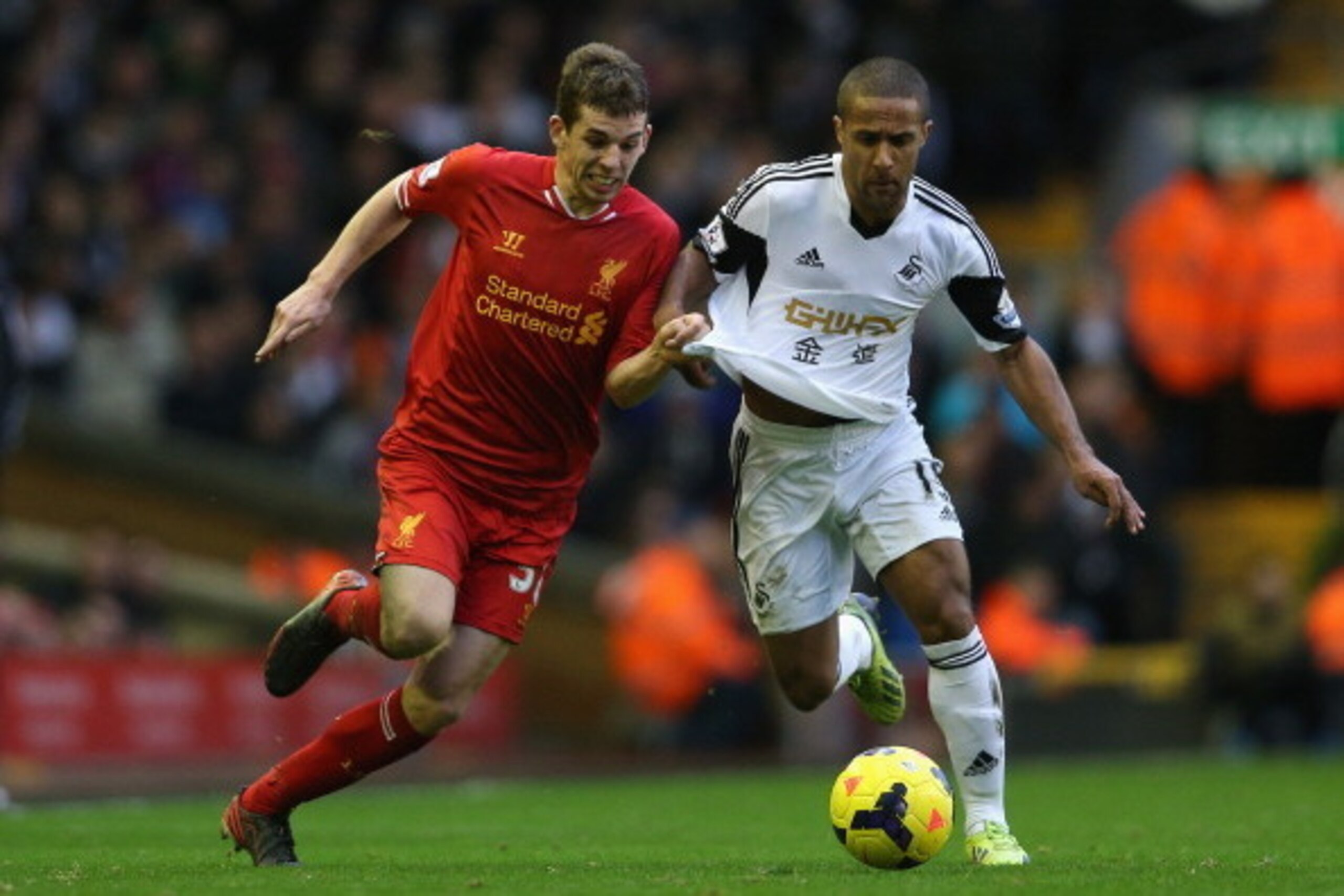 LIVERPOOL, ENGLAND - FEBRUARY 23:  Jon Flanagan of Liverpool battles with Wayne Routledge of Swansea City during the Barclays Premier League match between Liverpool and Swansea City at Anfield on February 23, 2014 in Liverpool, England.  (Photo by Clive B