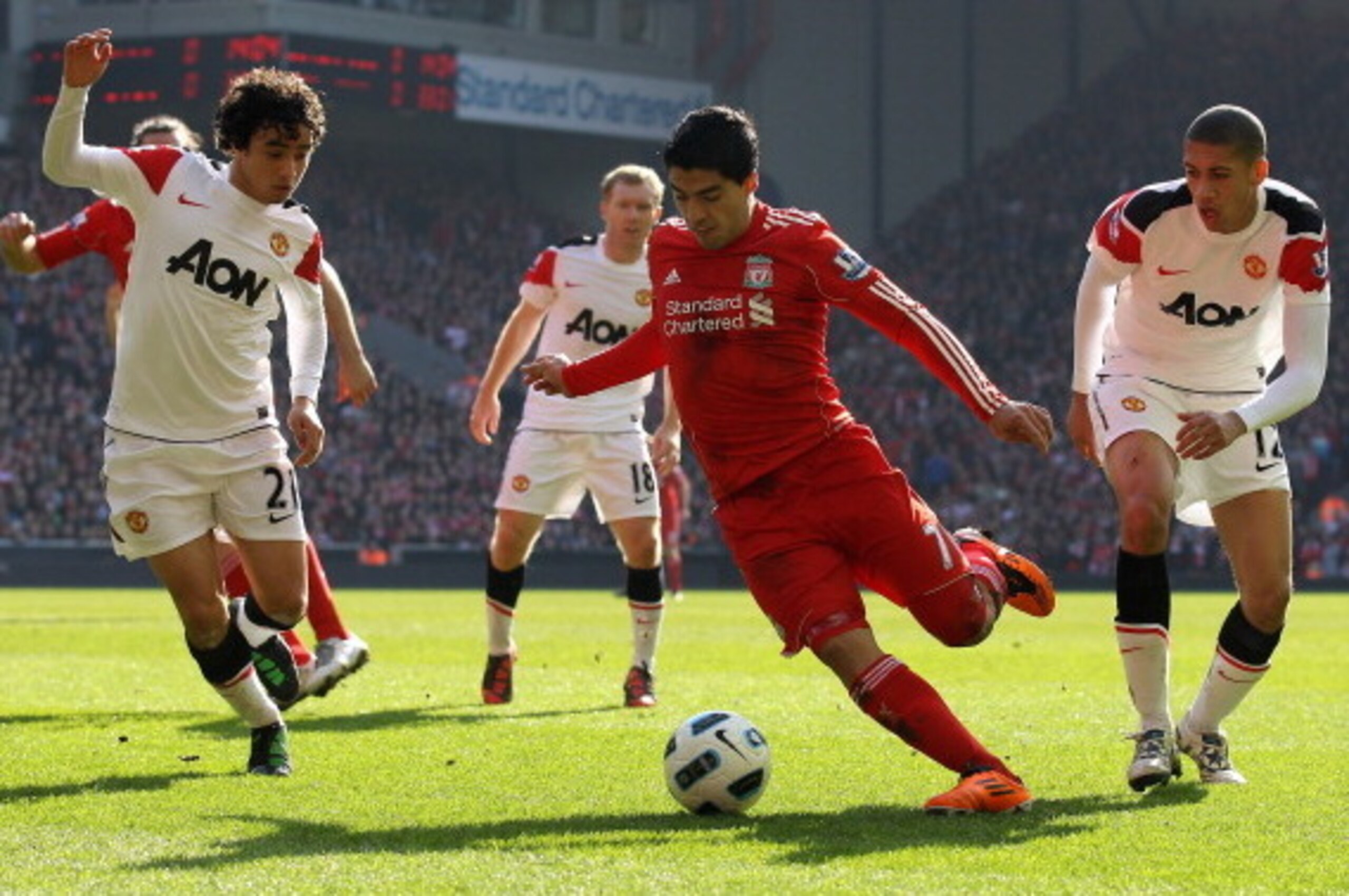 LIVERPOOL, ENGLAND - MARCH 06:  Luis Suarez of Liverpool goes clear of Chris Smalling and Rafael (L) of Manchester United to set up the first goal during the Barclays Premier League match between Liverpool and Manchester United at Anfield on March 6, 2011