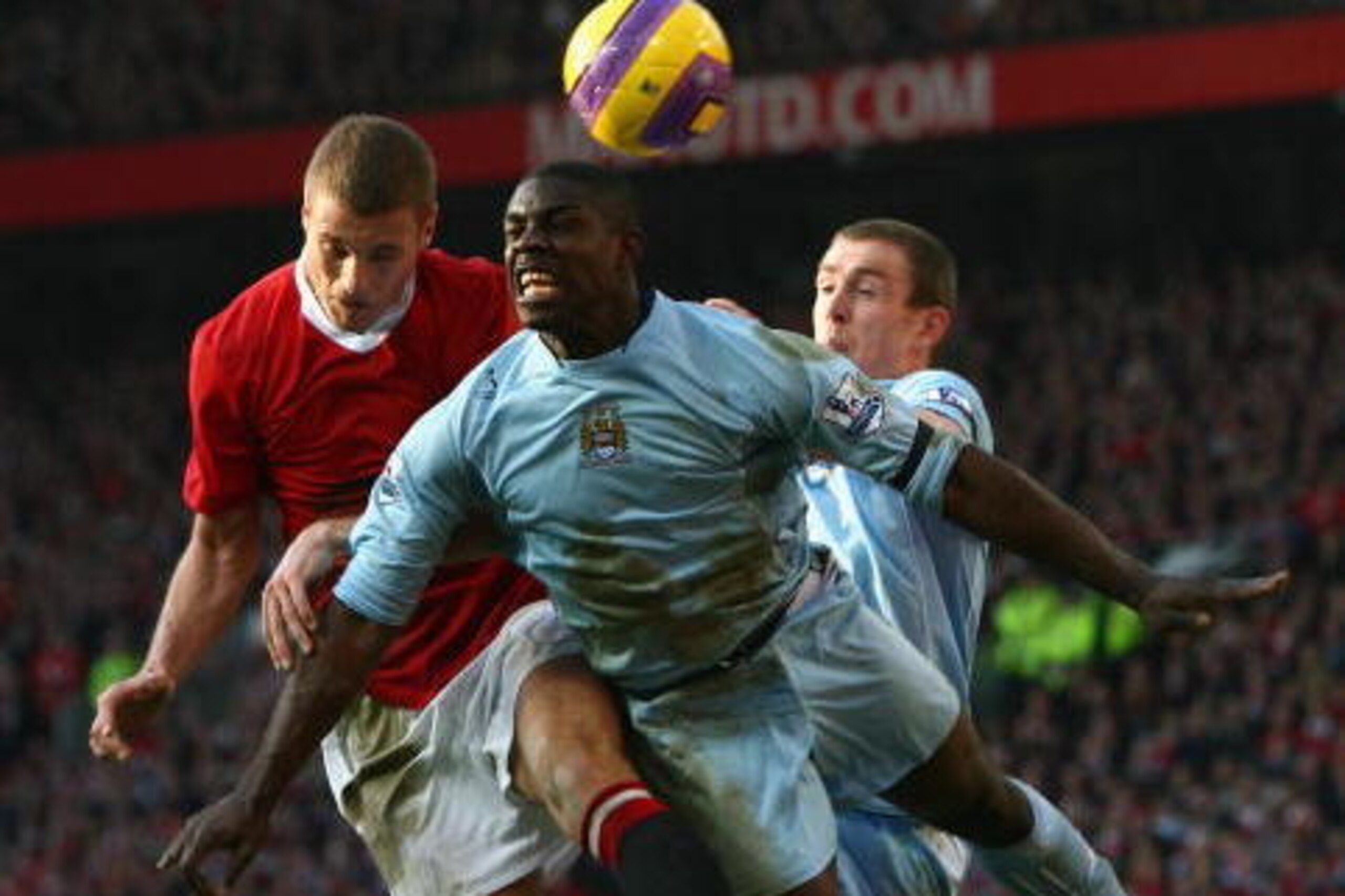 MANCHESTER, UNITED KINGDOM - FEBRUARY 10:  Micah Richards of Manchester City leaps to get his head to the ball before Nemanja Vidic of Manchester United and team mate Richard Dunne (R) during the Barclays Premier League match between Manchester United and