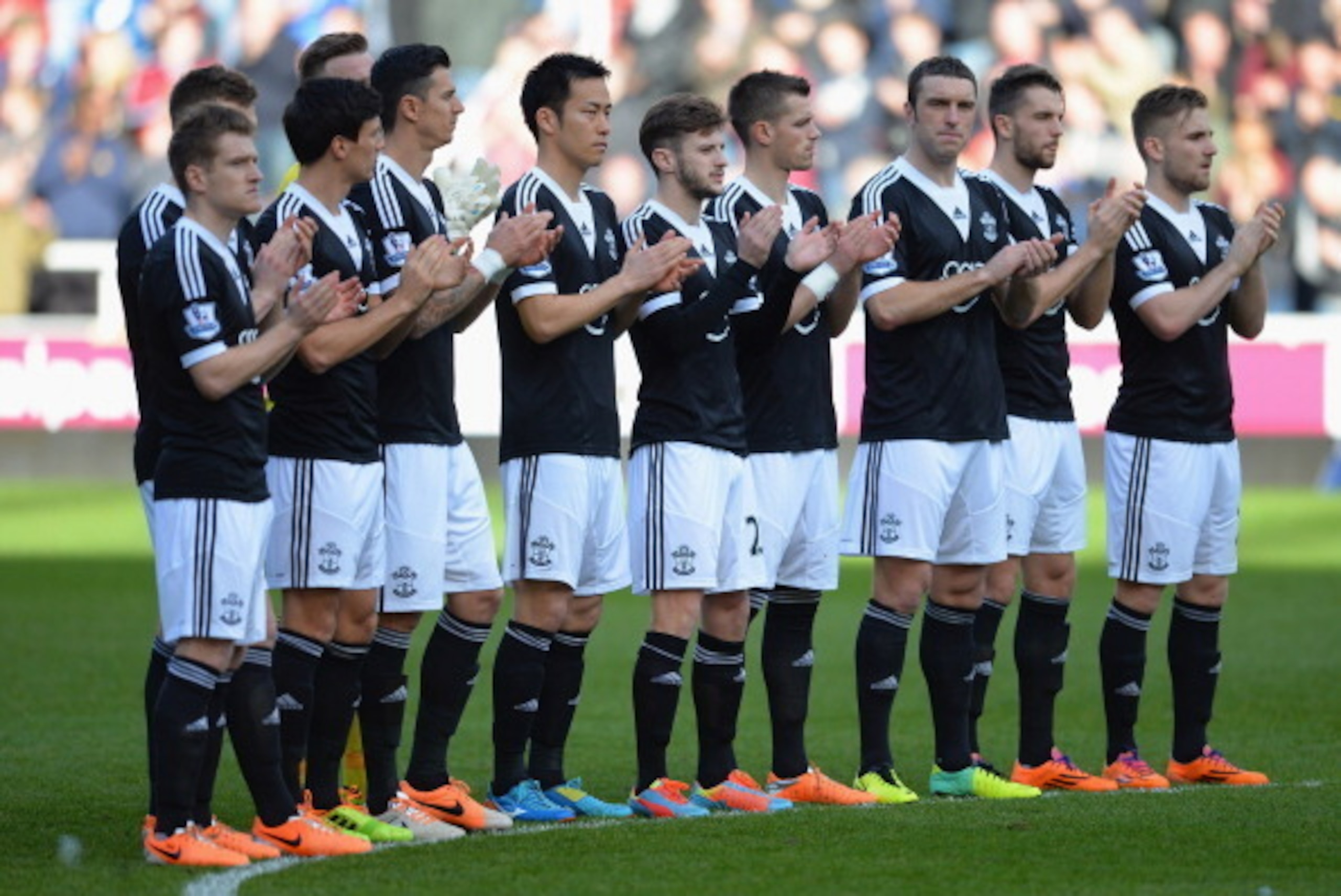 LONDON, ENGLAND - FEBRUARY 22:  The Southampton team with their bright cloured football boots during the minute applause for Tom Finney during the Barclays Premier League match between West Ham United and Southampton at Boleyn Ground on February 22, 2014 