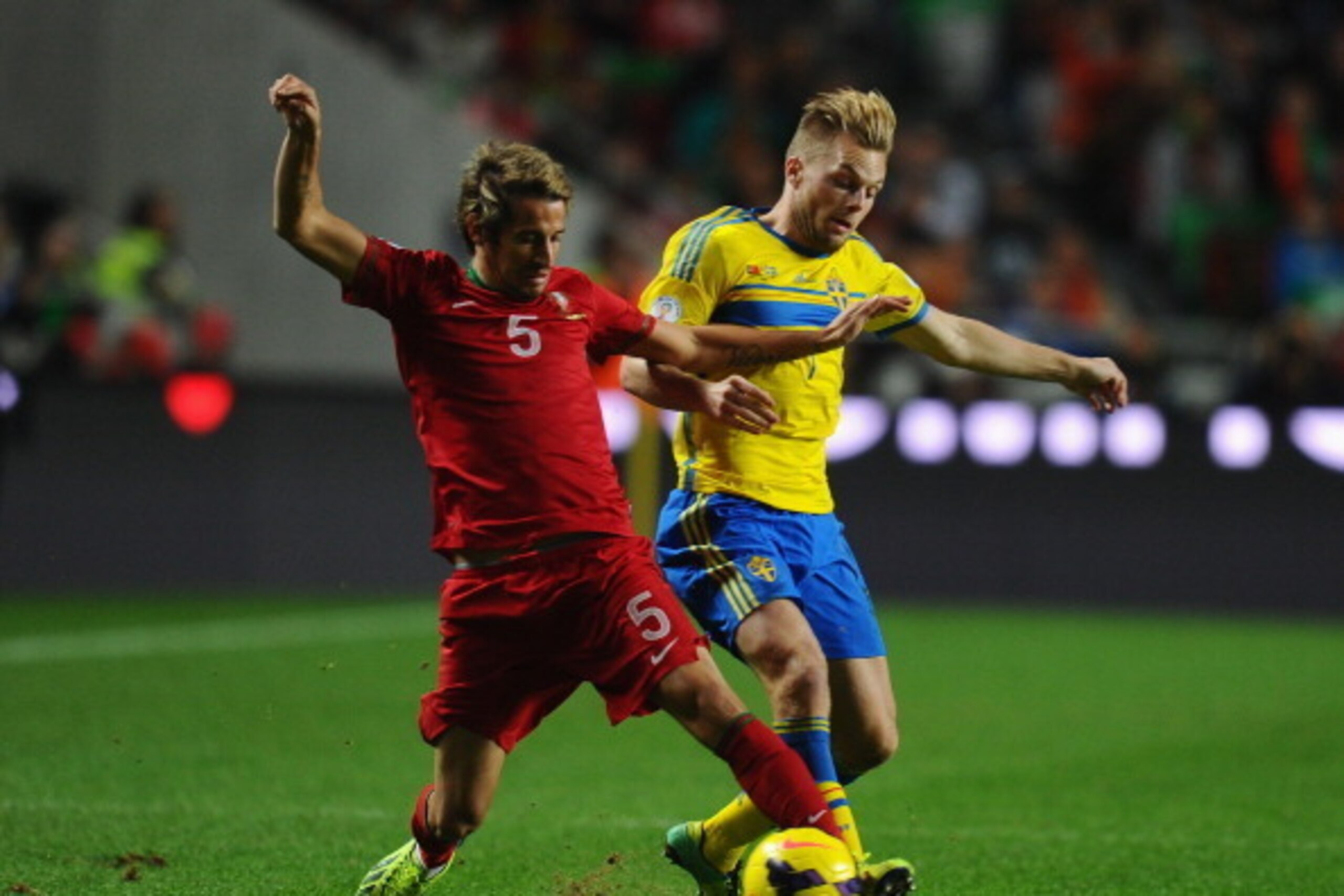 LISBON, PORTUGAL - NOVEMBER 15:  Fabio Coentrao of Portugal battles with Sebastian Larsson of Sweden during the FIFA 2014 World Cup Qualifier Play-off First Leg between Portugal and Sweden at Estadio da Luz on November 15, 2013 in Lisbon, Portugal.  (Phot