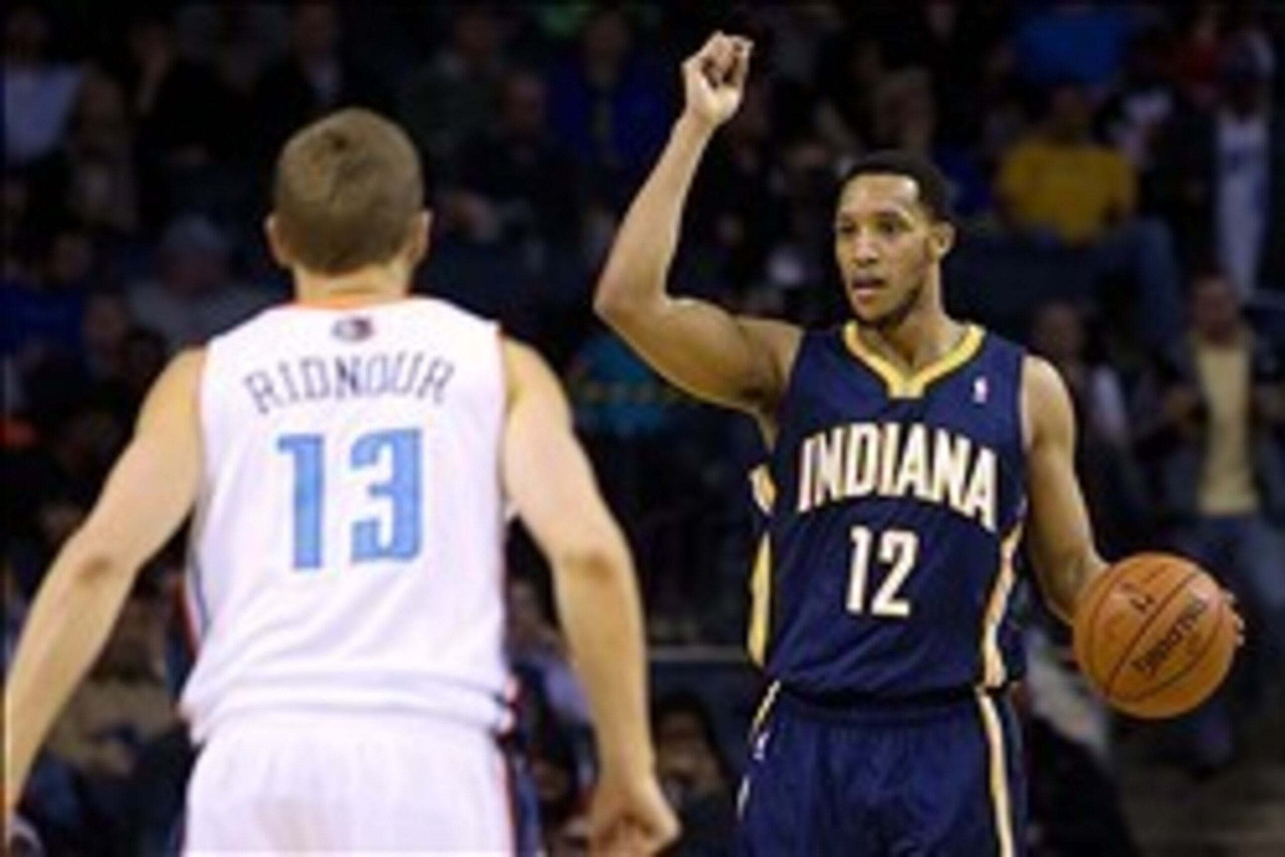 Mar 5, 2014; Charlotte, NC, USA; Indiana Pacers small forward Evan Turner (12) calls a play while being defended by Charlotte Bobcats point guard Luke Ridnour (13) during the second half at Time Warner Cable Arena. Bobcats won 109-87. Mandatory Credit: Jo