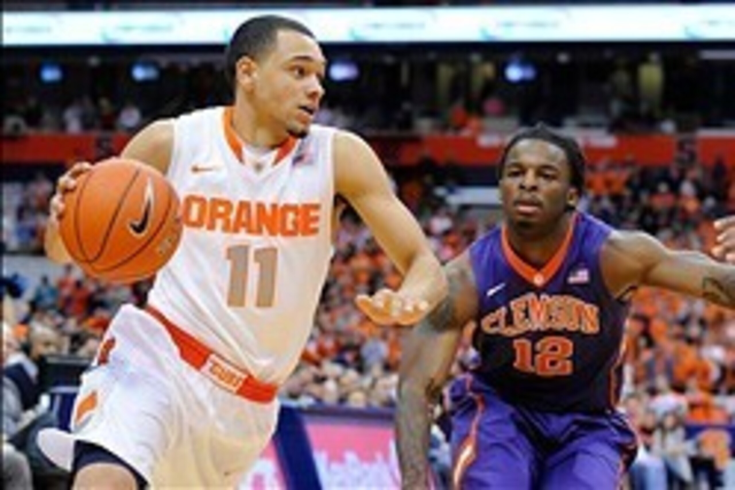 Feb 9, 2014; Syracuse, NY, USA; Syracuse Orange guard Tyler Ennis (11) dribbles the ball in front of Clemson Tigers guard Rod Hall (12) during the first half at the Carrier Dome.  Mandatory Credit: Rich Barnes-USA TODAY Sports