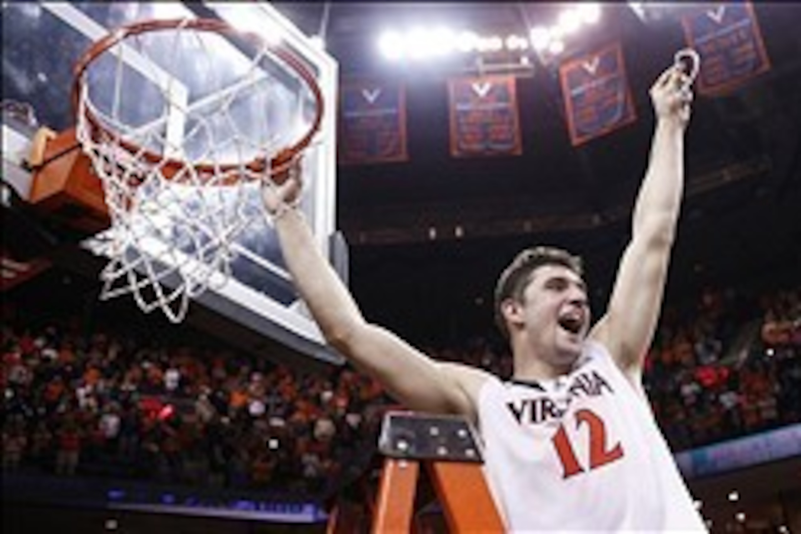Mar 1, 2014; Charlottesville, VA, USA; Virginia Cavaliers guard Joe Harris (12) celebrates with the net after the Cavaliers game against the Syracuse Orange at John Paul Jones Arena. The Cavaliers won 75-56 and clinched the ACC regular season title. Manda