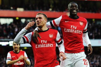 LONDON, ENGLAND - FEBRUARY 16:  Lukas Podolski (L) of Arsenal celebrates with team mate Yaya Sanogo after scoring during the FA Cup Fifth Round match between Arsenal and Liverpool at the Emirates Stadium on February 16, 2014 in London, England.  (Photo by