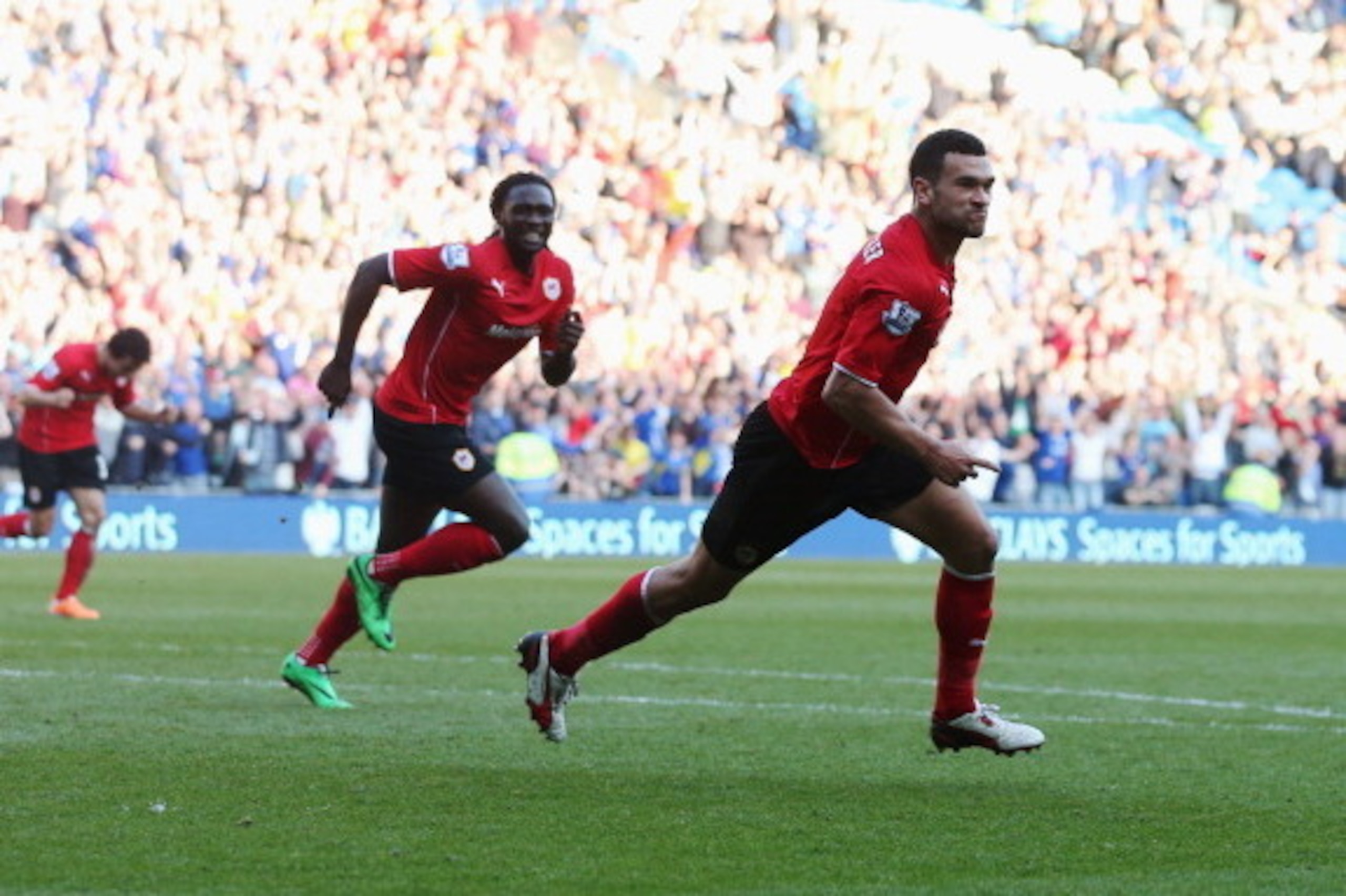 CARDIFF, WALES - MARCH 08:  Steven Caulker of Cardiff City (R) celebrates with Kenwyne Jones as he scores their second goal during the Barclays Premier League match between Cardiff City and Fulham at Cardiff City Stadium on March 8, 2014 in Cardiff, Wales