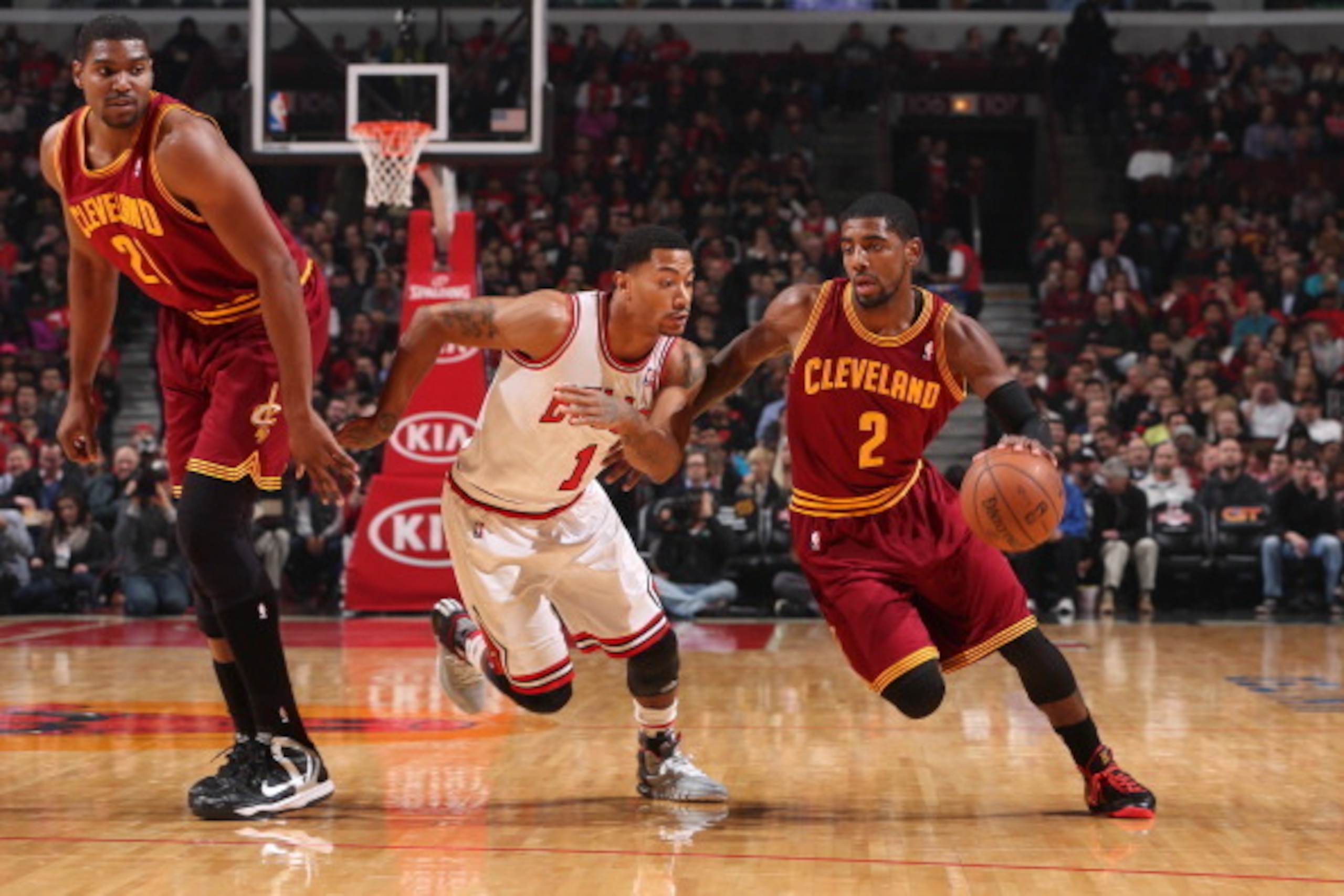 CHICAGO, IL - NOVEMBER 11: Derrick Rose #1 of the Chicago Bulls guards Kyrie Irving #2 of the Cleveland Cavaliers as Andrew Bynum #21 of the Cavaliers watches from the side on November 11, 2013 at the United Center in Chicago, Illinois. NOTE TO USER: User