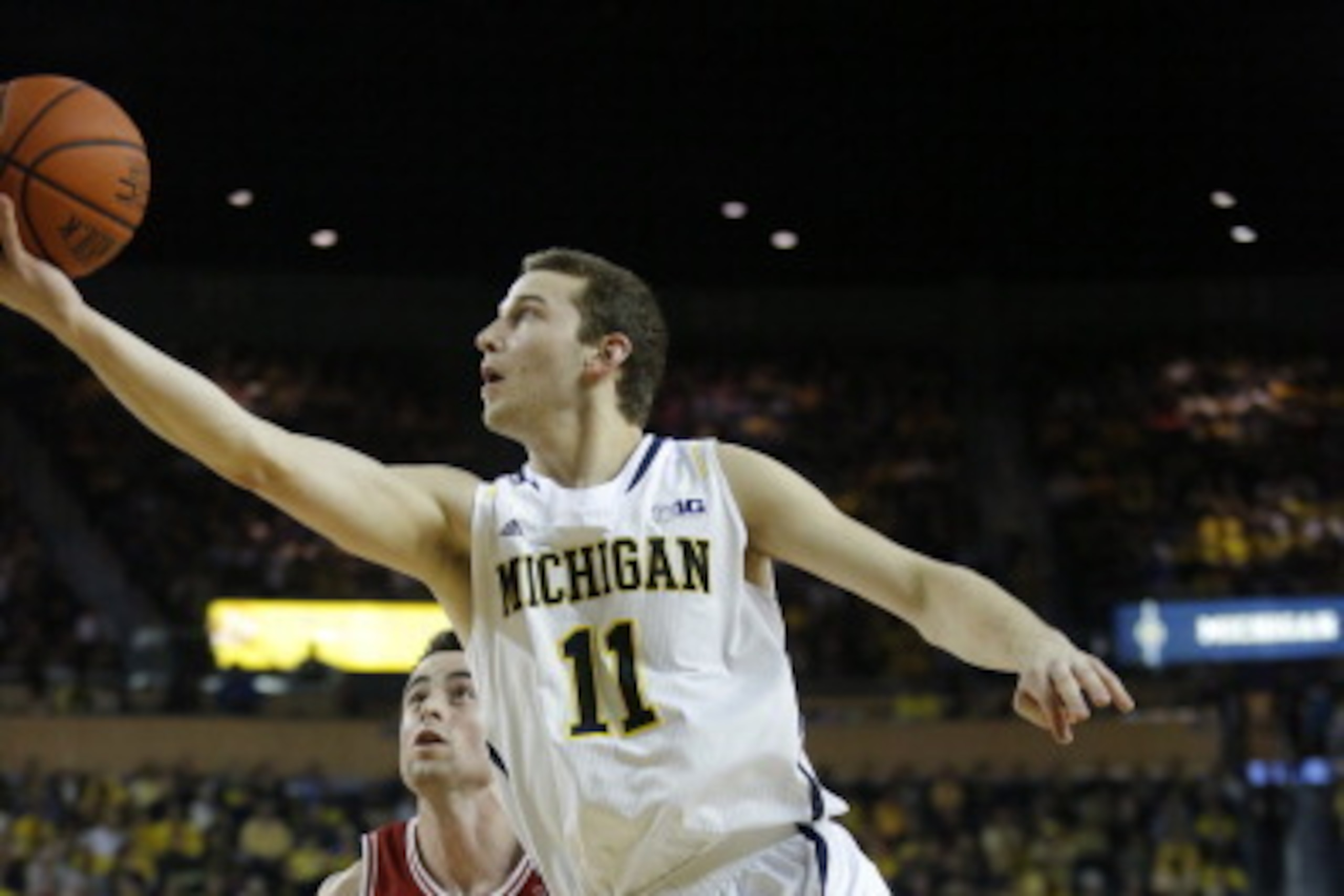 ANN ARBOR, MI - MARCH 8:  Nik Stauskas #11 of the Michigan Wolverines goes in for a layup past Will Sheehey #0 of the Indiana Hoosiers during the first half of a basketball game on March 8, 2014, in Ann Arbor, Michigan. (Photo by Duane Burleson/Getty Imag