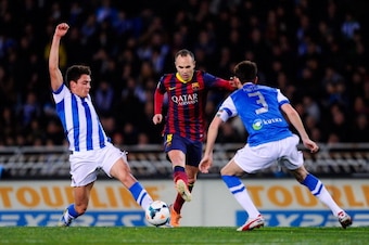 SAN SEBASTIAN, SPAIN - FEBRUARY 22:  Andres Iniesta of FC Barcelona duels for the ball with Gorka Elustondo Urkola (L) and Mikel Gonzalez Martinez of Real Sociedad during the La Liga match between Real Sociedad and FC Barcelona at Estadio Anoeta on Februa