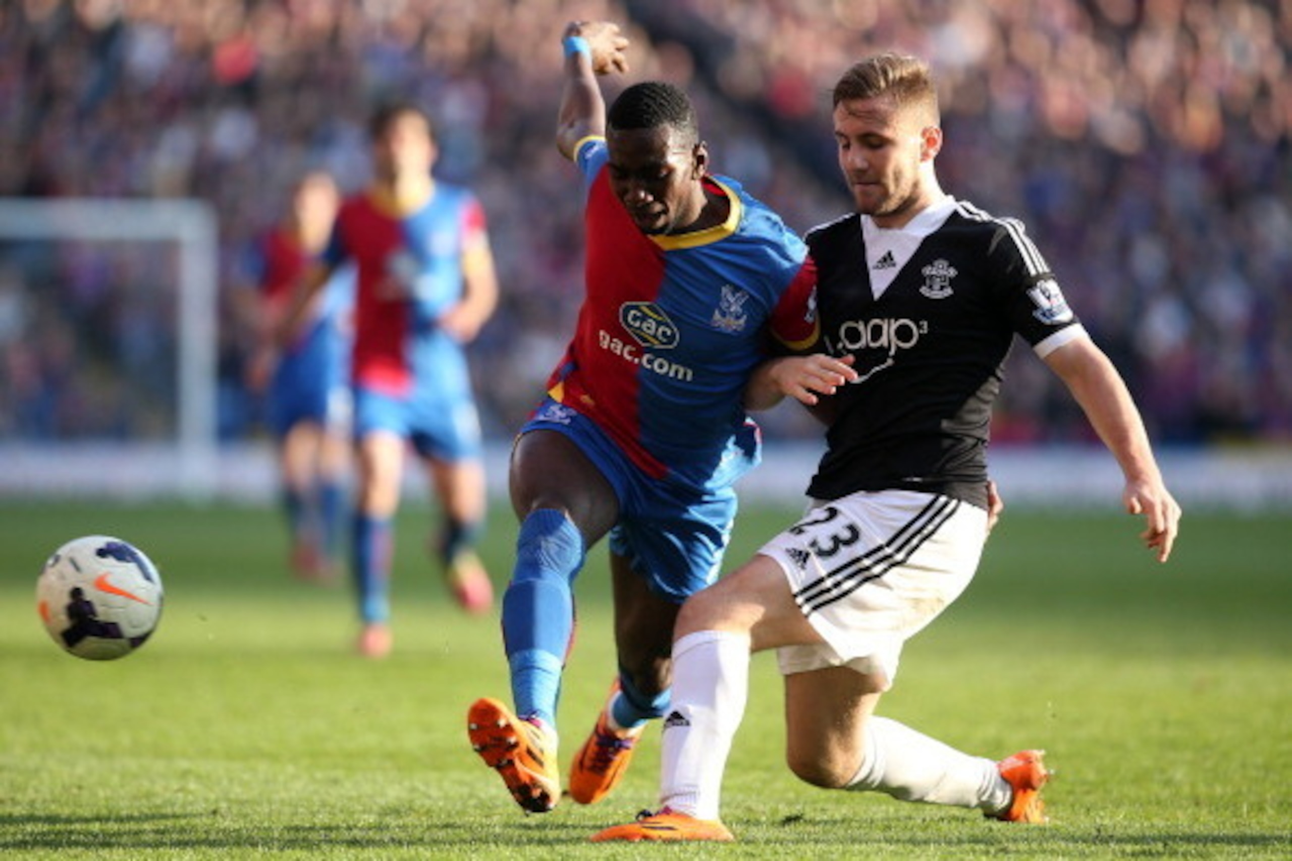 LONDON, ENGLAND - MARCH 08: Yannick Bolasie of Palace tries to get past Luke Shaw of Southampton during the Barclays Premier League match between Crystal Palace and Southampton at Selhurst Park on March 08, 2014 in London, England. (Photo by Charlie Crowh