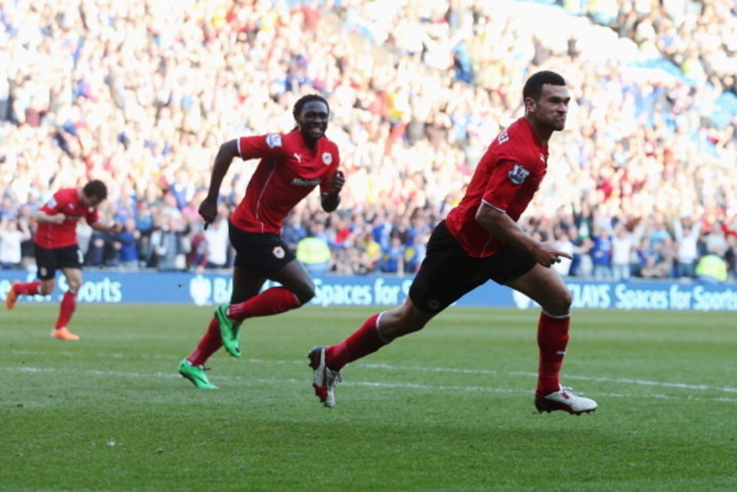 CARDIFF, WALES - MARCH 08:  Steven Caulker of Cardiff City (R) celebrates with Kenwyne Jones as he scores their second goal during the Barclays Premier League match between Cardiff City and Fulham at Cardiff City Stadium on March 8, 2014 in Cardiff, Wales