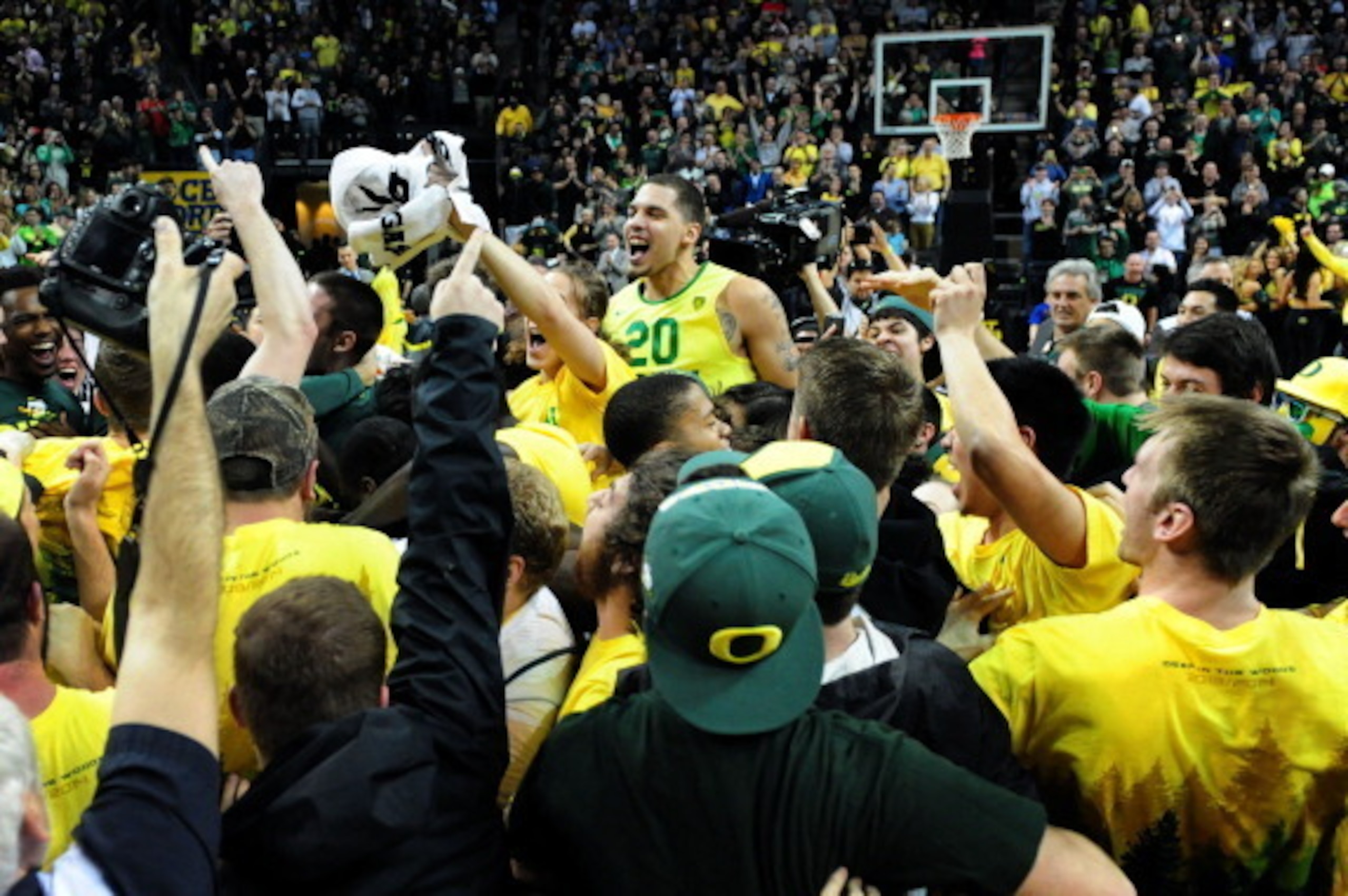 EUGENE, OR - MARCH 8: Waverly Austin #20 of the Oregon Ducks is lifted up in the air by Oregon fans who stormed the court after the game against the Arizona Wildcats at Matthew Knight Arena on March 8, 2014 in Eugene, Oregon. Oregon won the game 64-57. (P