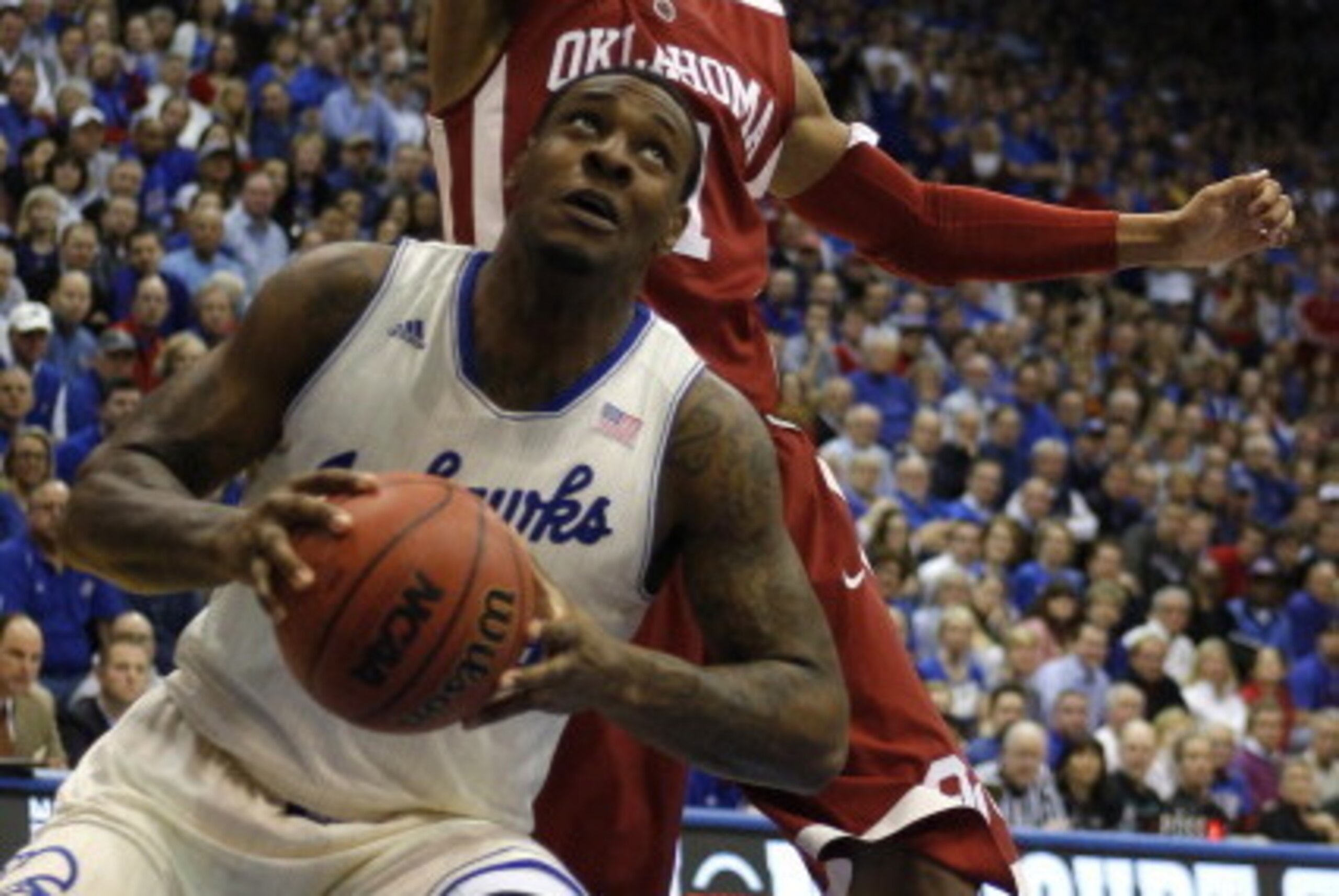 LAWRENCE, KS - FEBRUARY 24:  Tarik Black #25 of the Kansas Jayhawks looks to shoot against Isaiah Cousins #11 of the Oklahoma Sooners in the first half at Allen Fieldhouse on February 24, 2014 in Lawrence, Kansas. (Photo by Ed Zurga/Getty Images)