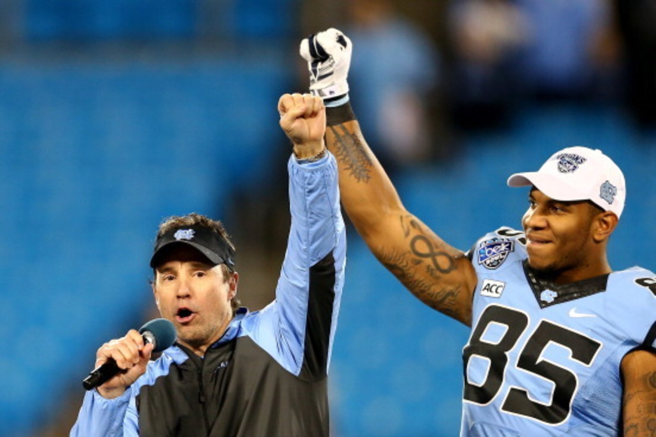 CHARLOTTE, NC - DECEMBER 28:  Head coach Larry Fedora of the North Carolina Tar Heels celebrates with Eric Ebron #85 after defeating the Cincinnati Bearcats 39-17 at Bank of America Stadium on December 28, 2013 in Charlotte, North Carolina.  (Photo by Str
