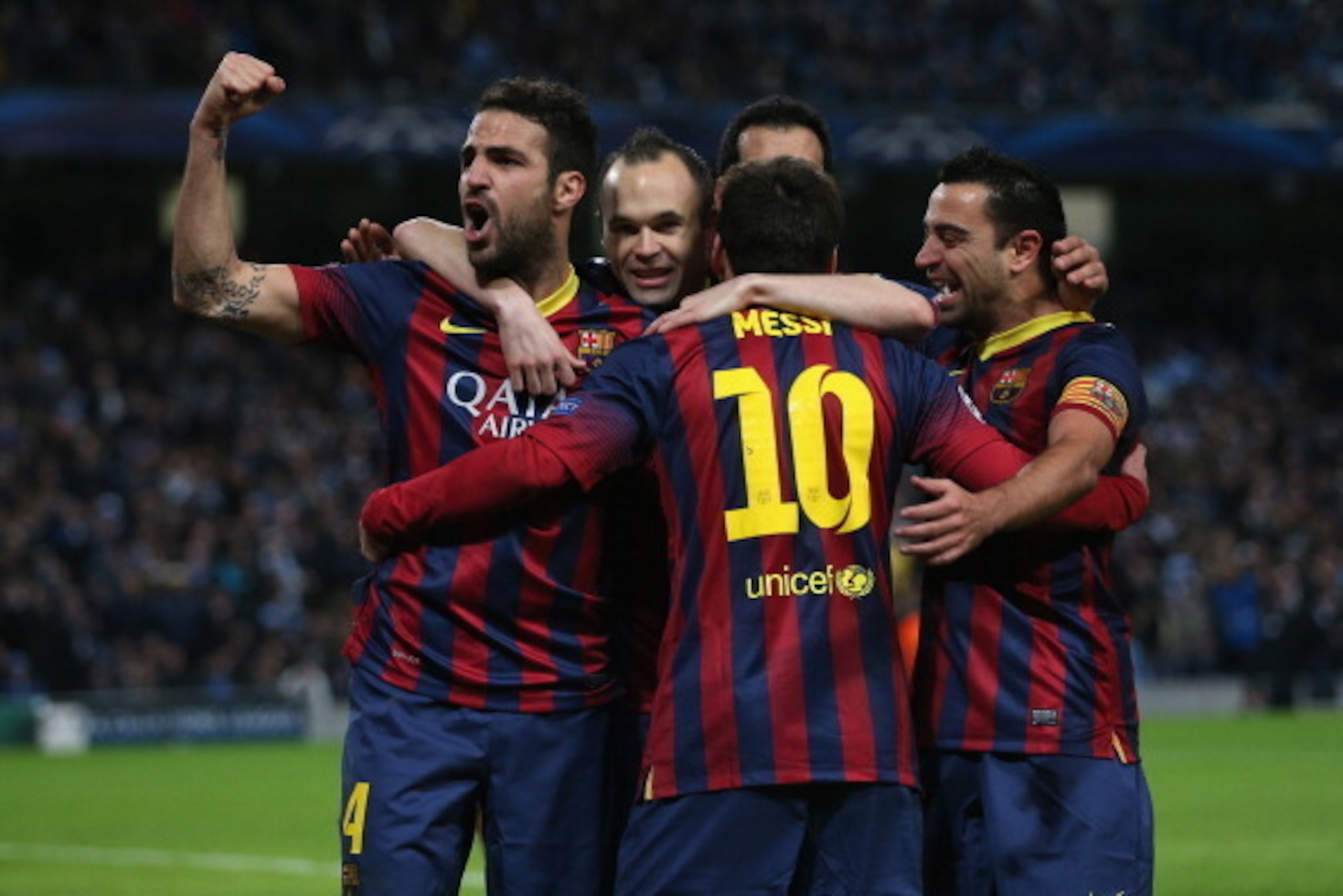 MANCHESTER, ENGLAND - FEBRUARY 18:  Lionel Messi of Barcelona celebrates scoring the opening goal from a penalty kick with his team-mates during the UEFA Champions League Round of 16 first leg match between Manchester City and Barcelona at the Etihad Stad