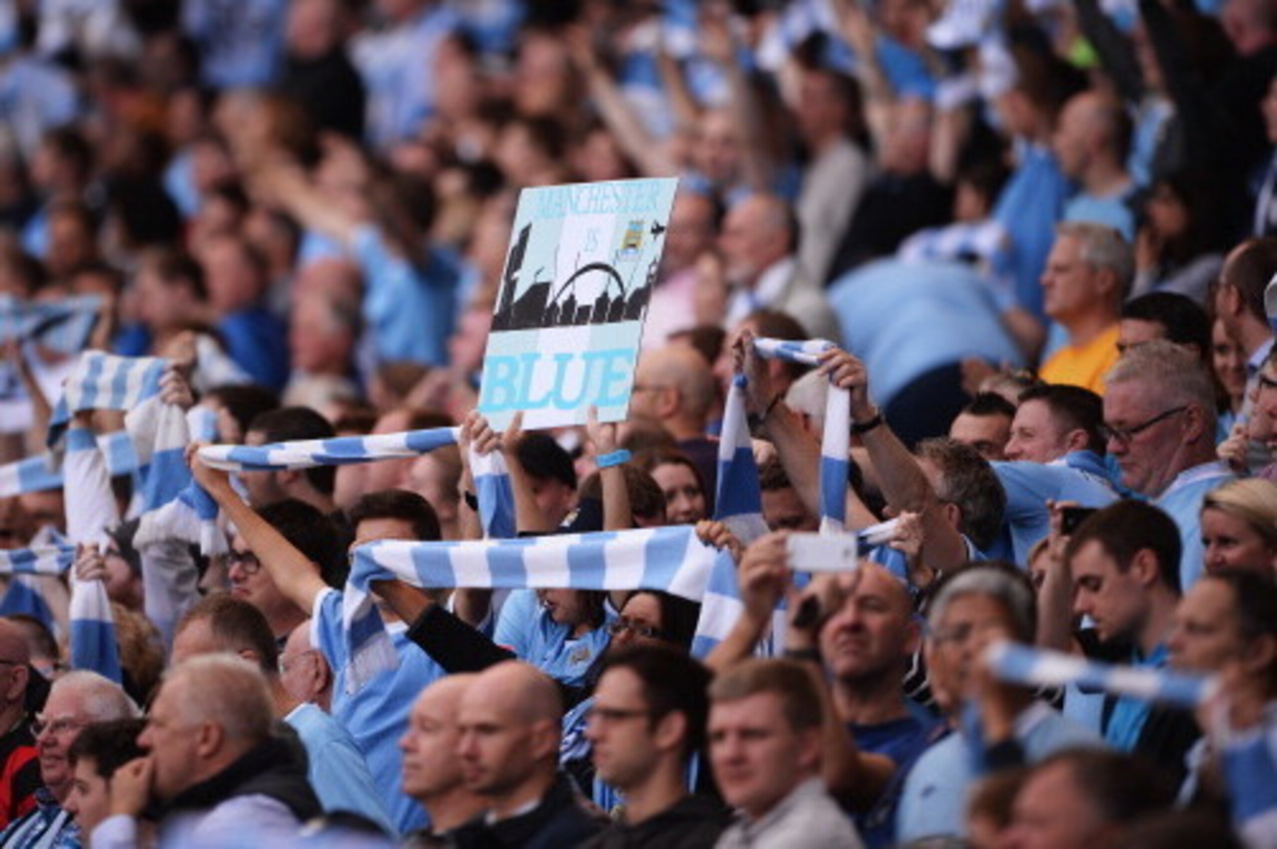 MANCHESTER, ENGLAND - SEPTEMBER 22:  Manchester City fans show their support before the start of the Barclays Premier League match between Manchester City and Manchester United at the Etihad Stadium on September 22, 2013 in Manchester, England.  (Photo by
