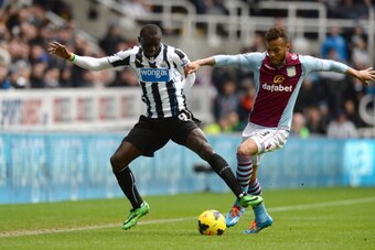 NEWCASTLE UPON TYNE, ENGLAND - FEBRUARY 23:  Pappis Cisse of Newcastle United tackled by Ryan Bertrand of Aston Villa during the Barclays Premier League match between Newcastle United and Aston Villa at St James' Park on February 23, 2014 in Newcastle upo