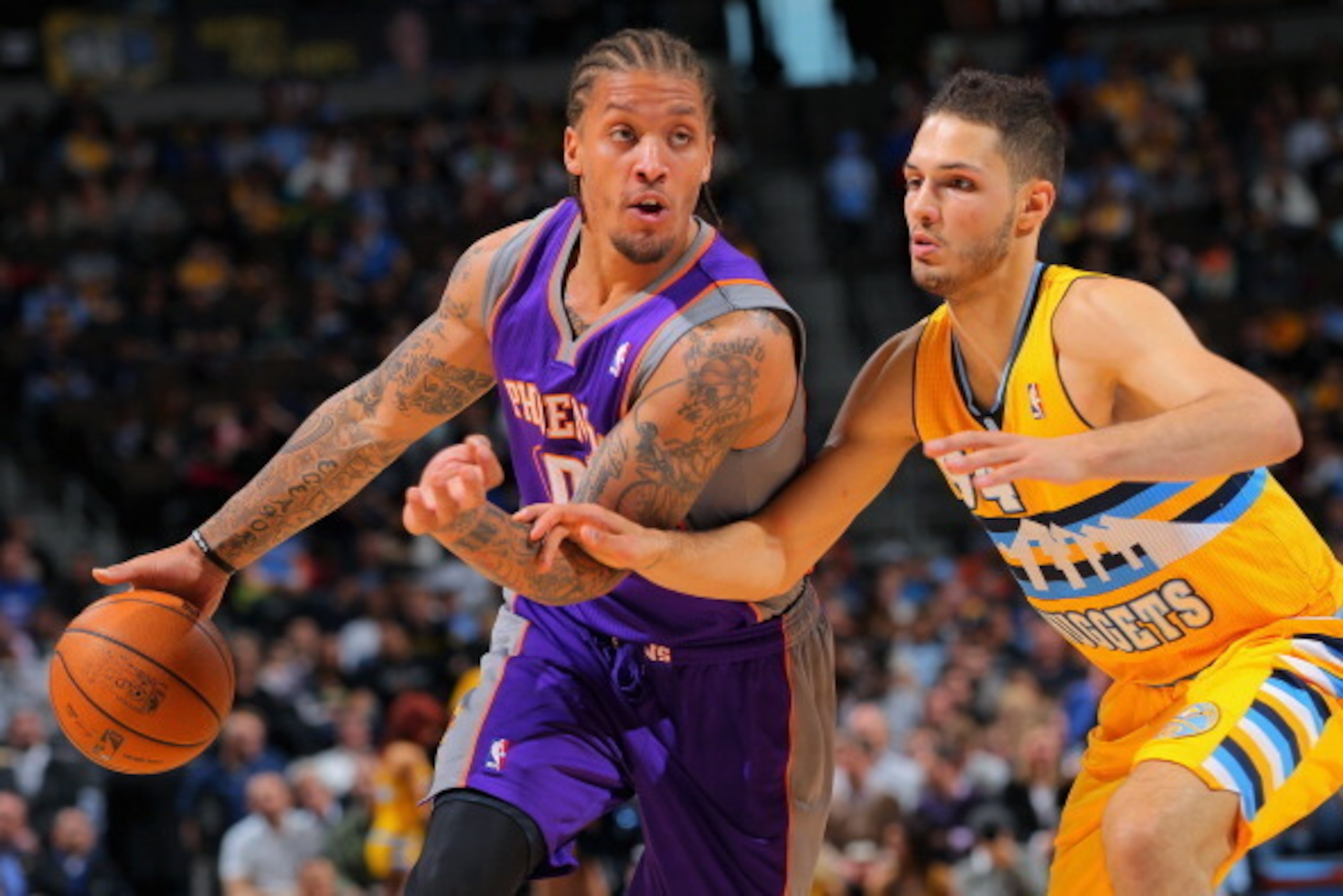 DENVER, CO - APRIL 17:  Michael Beasley #0 of the Phoenix Suns controls the ball against Evan Fournier #94 of the Denver Nuggets at the Pepsi Center on April 17, 2013 in Denver, Colorado. NOTE TO USER: User expressly acknowledges and agrees that, by downl