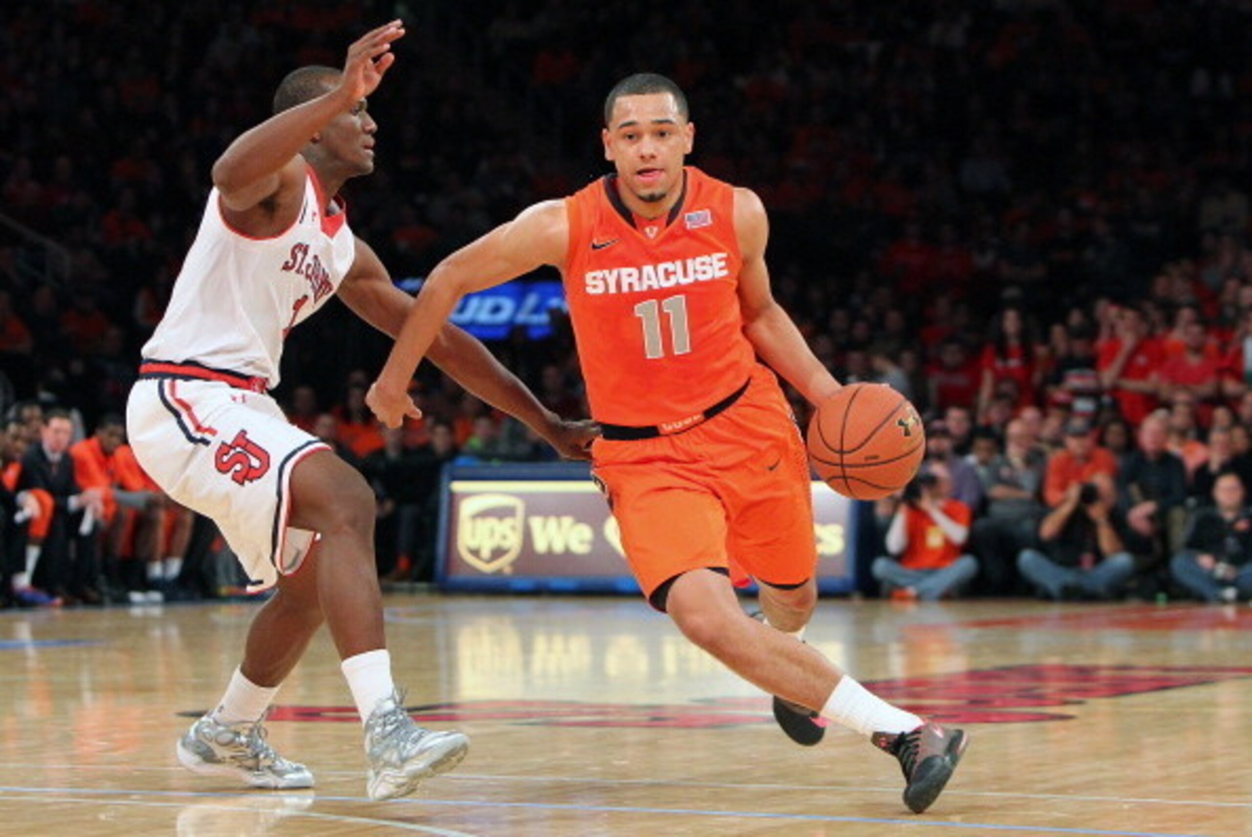 NEW YORK, NY - DECEMBER 15:  Tyler Ennis #11 of the Syracuse Orange drives the ball down the court against Phil Greene IV #1 of the St. John's Red Storm during the game at Madison Square Garden on December 15, 2013 in New York City. (Photo by Nate Shron/G