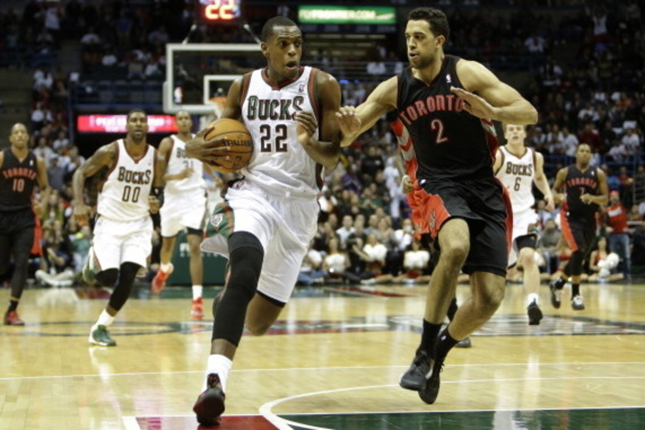 MILWAUKEE, WI - NOVEMBER 2: Khris Middleton #22 of the Milwaukee Bucks dibbles up the court on a fast break with Landry Fields #2 of the Toronto Raptors defending during the second half of action at Bradley Center on November 2, 2013 in Milwaukee, Wiscons