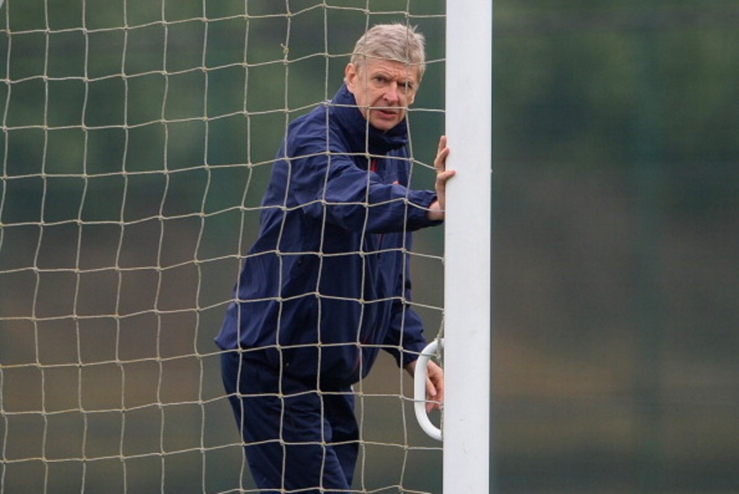 ST ALBANS, ENGLAND - MARCH 10:  Arsenal manager Arsene Wenger moves the goalposts during the Arsenal training session at London Colney on March 10, 2014 in St Albans, England.  (Photo by Michael Regan/Getty Images)