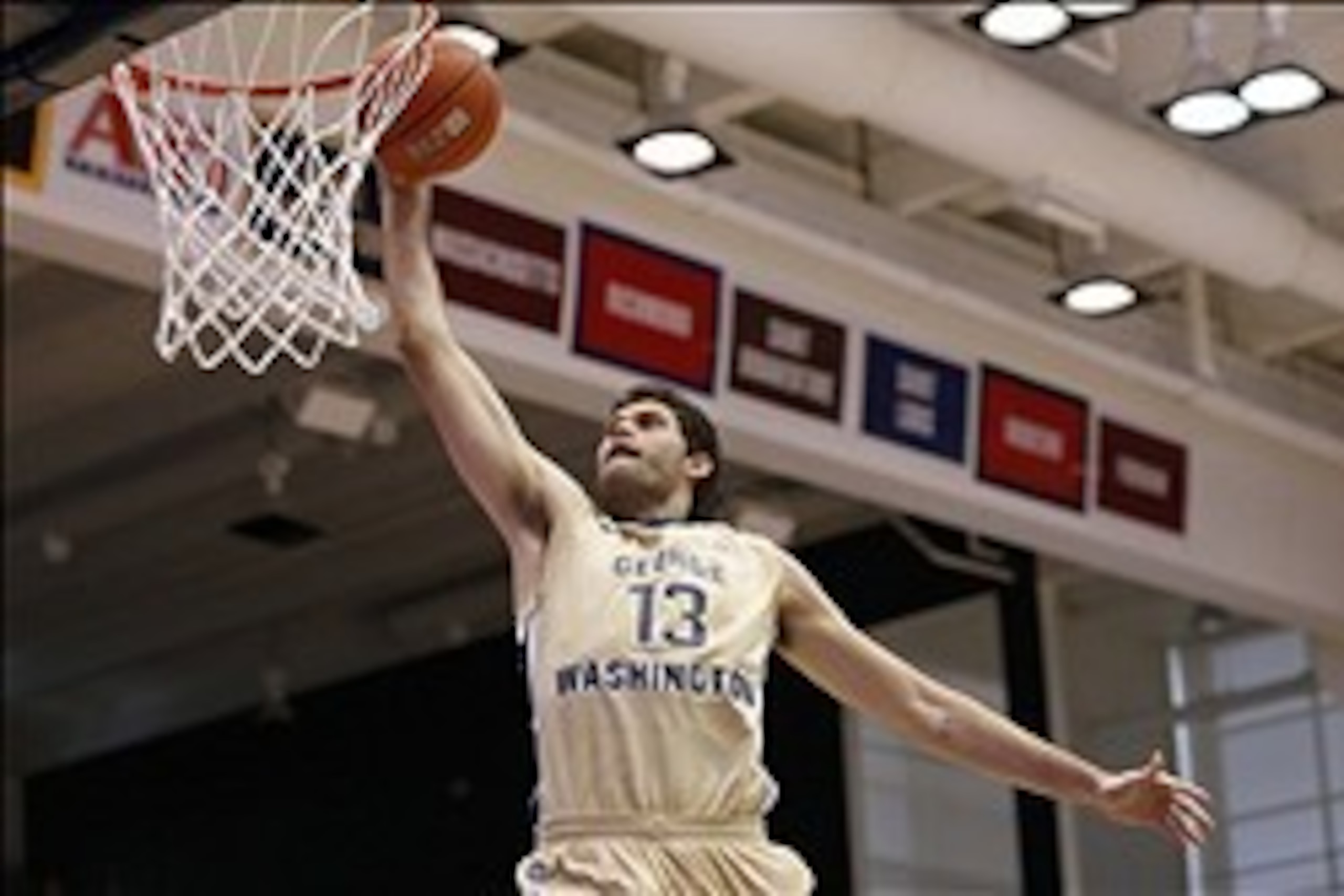 Feb 15, 2014; Washington, DC, USA; George Washington Colonials guard/forward Patricio Garino (13) dunks the ball against the Massachusetts Minutemen in the second half at Charles E. Smith Athletic Center. The Minutemen won 67-61. Mandatory Credit: Geoff B